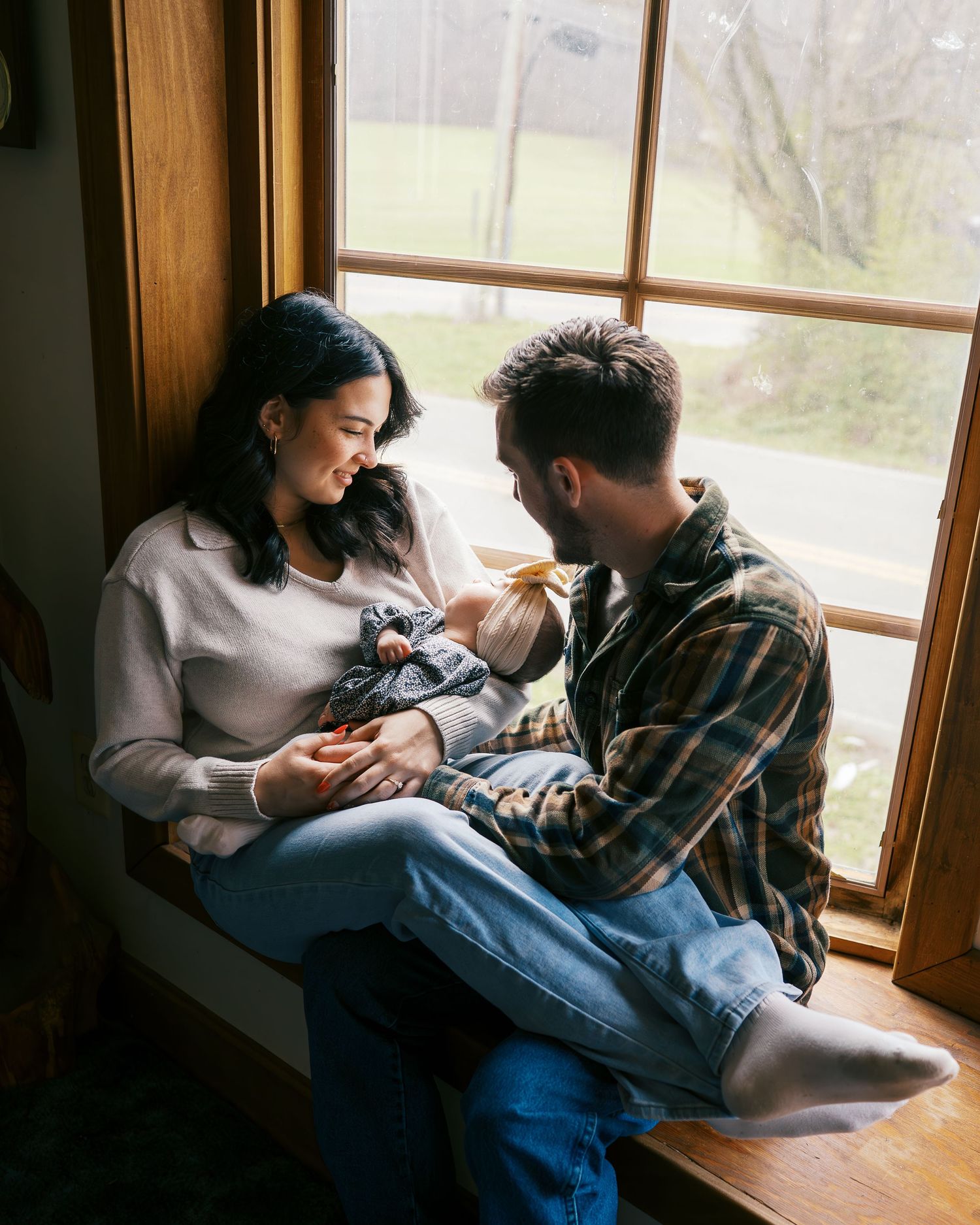 A couple relaxes together by a window seat in their home on a peaceful afternoon.