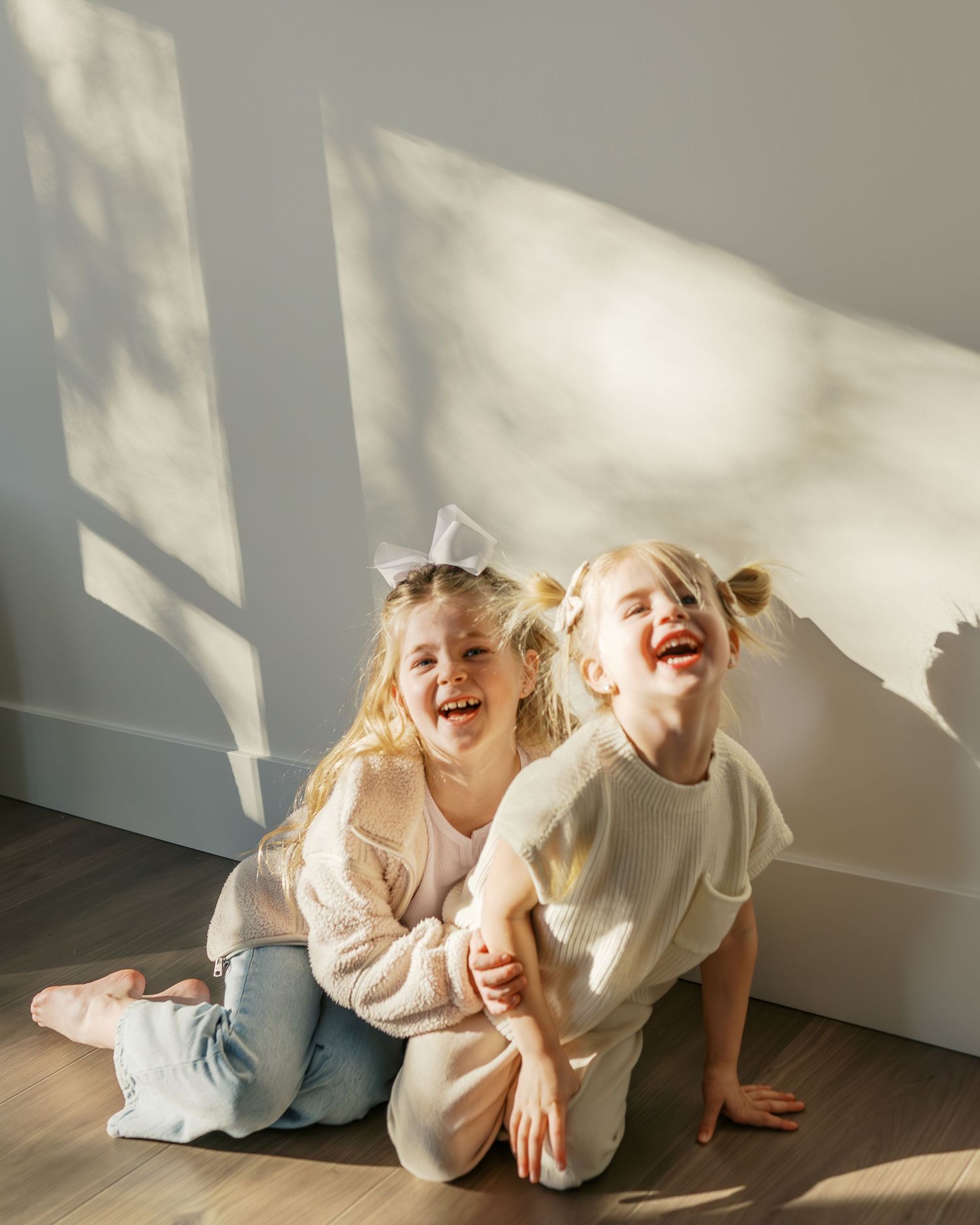 Candid playtime moments captured on hardwood floor in natural light.