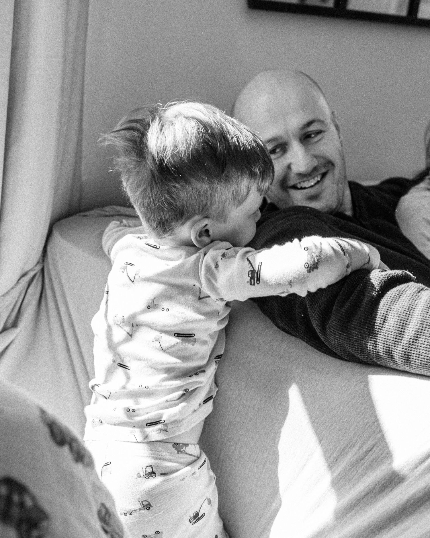 Black and white candid moment captured on cozy living room sofa in natural light.