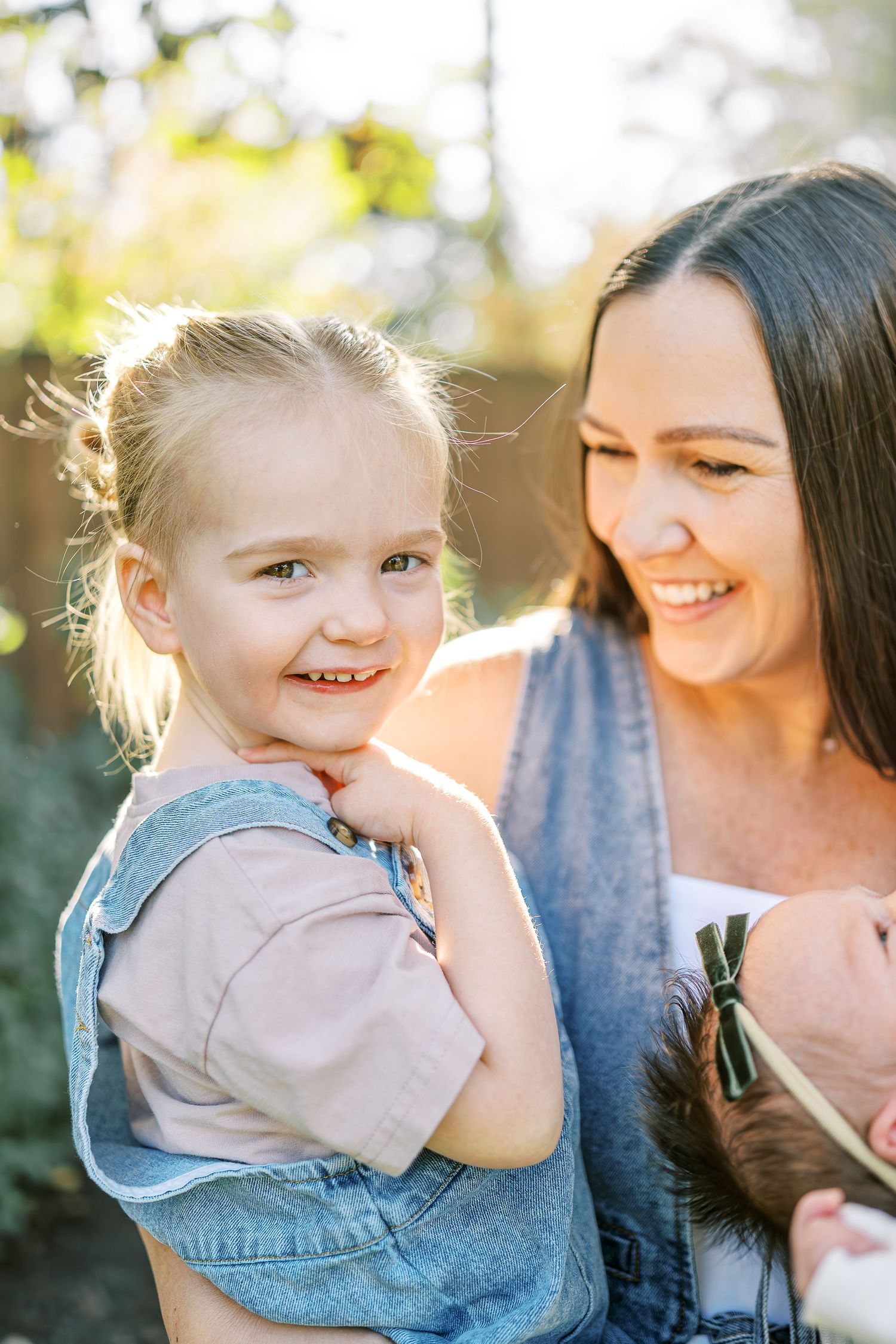 Sweet candid moments shared between family members as sunlight creates a warm backlit glow.