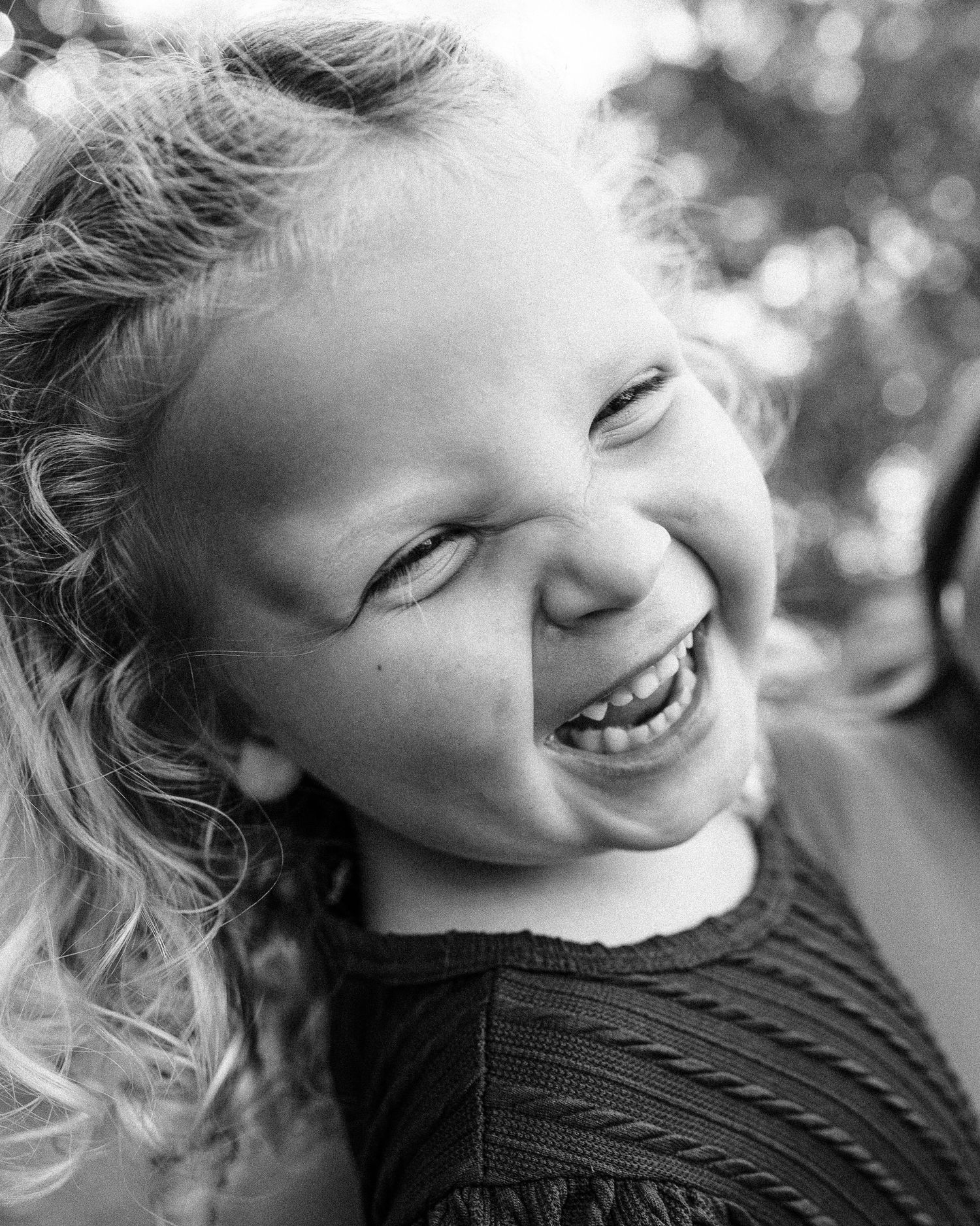 Black and white close-up sequence showing genuine laughter and expressions of joy.