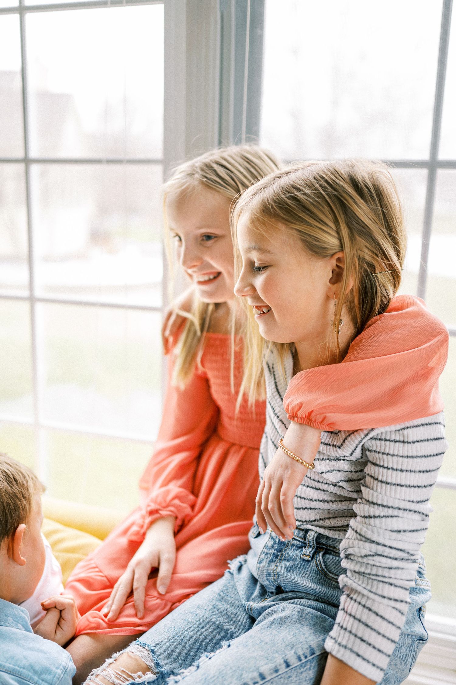 Casual family moments captured in a series of natural, candid shots by large windows.
