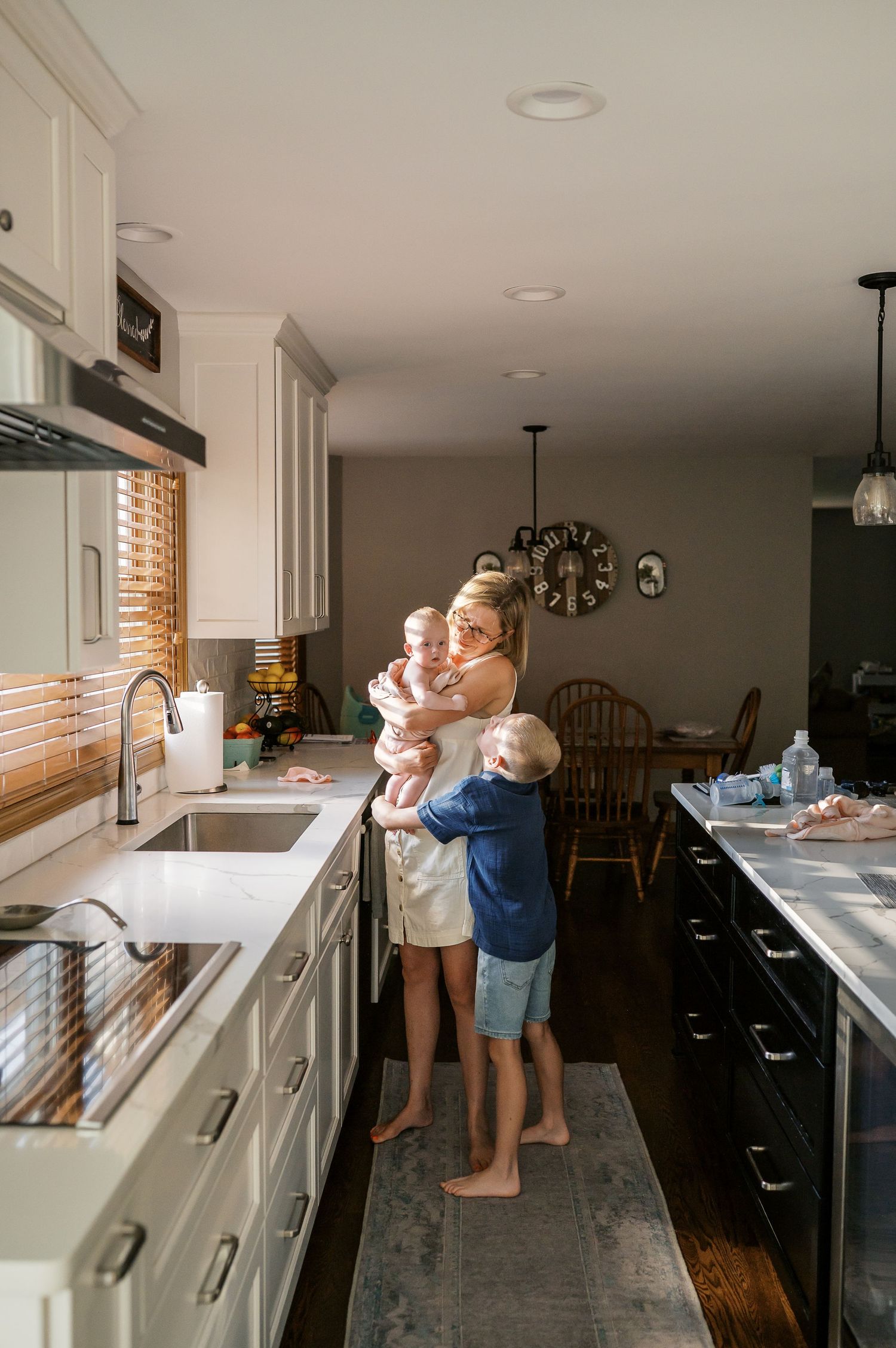 Family moment in modern kitchen with white cabinets and marble countertops.