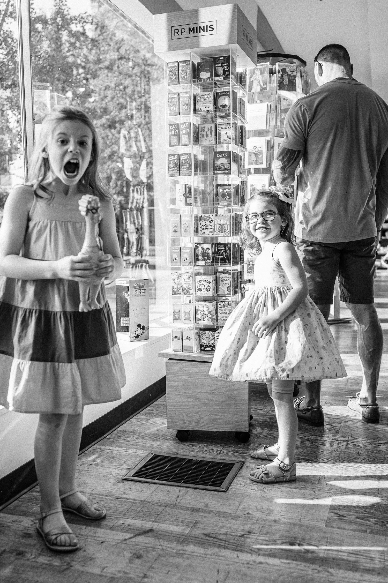 Black and white photo of excited children at a retail store display.