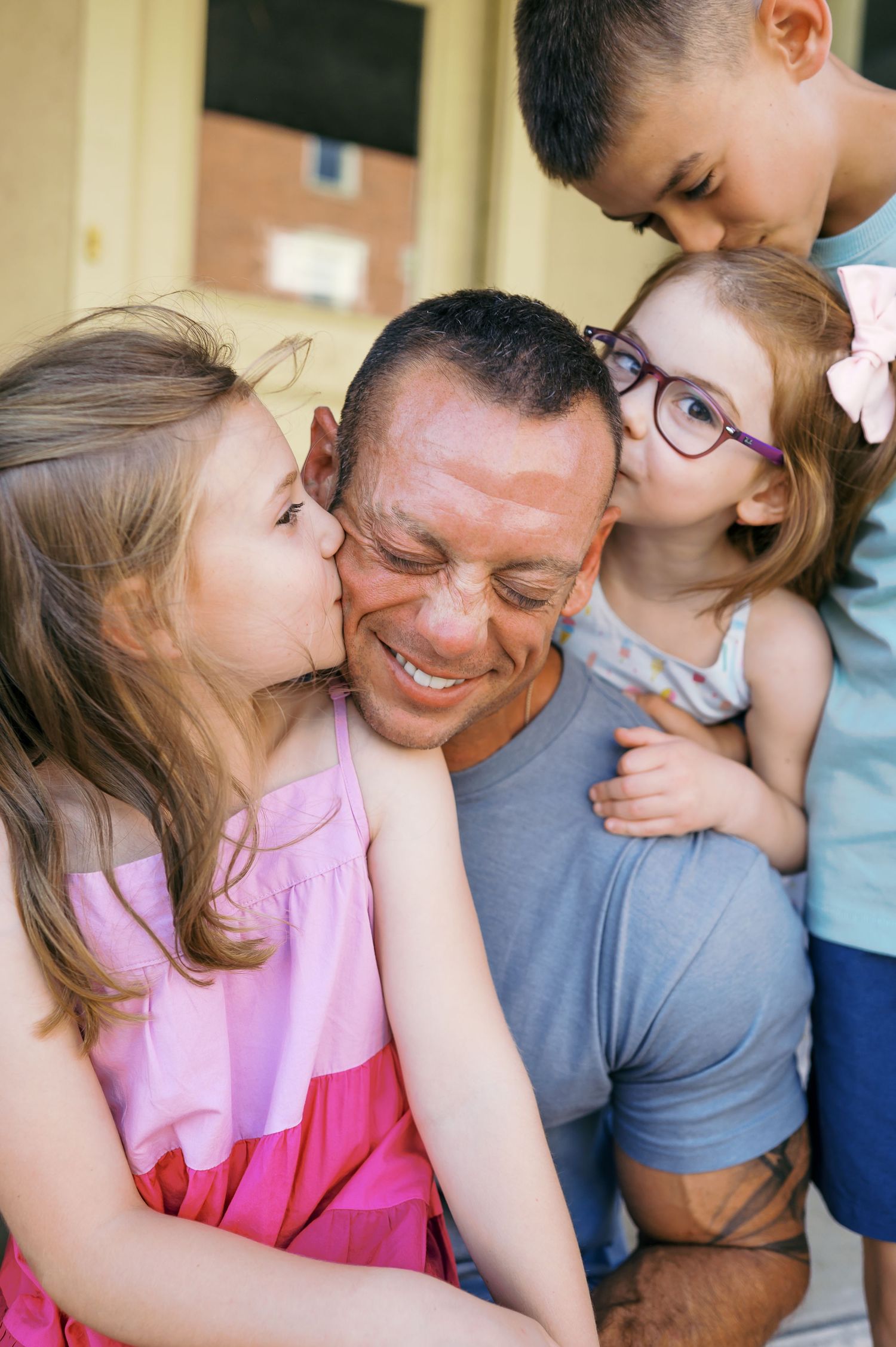 A close-up candid moment of a family sharing affectionate embraces outdoors.