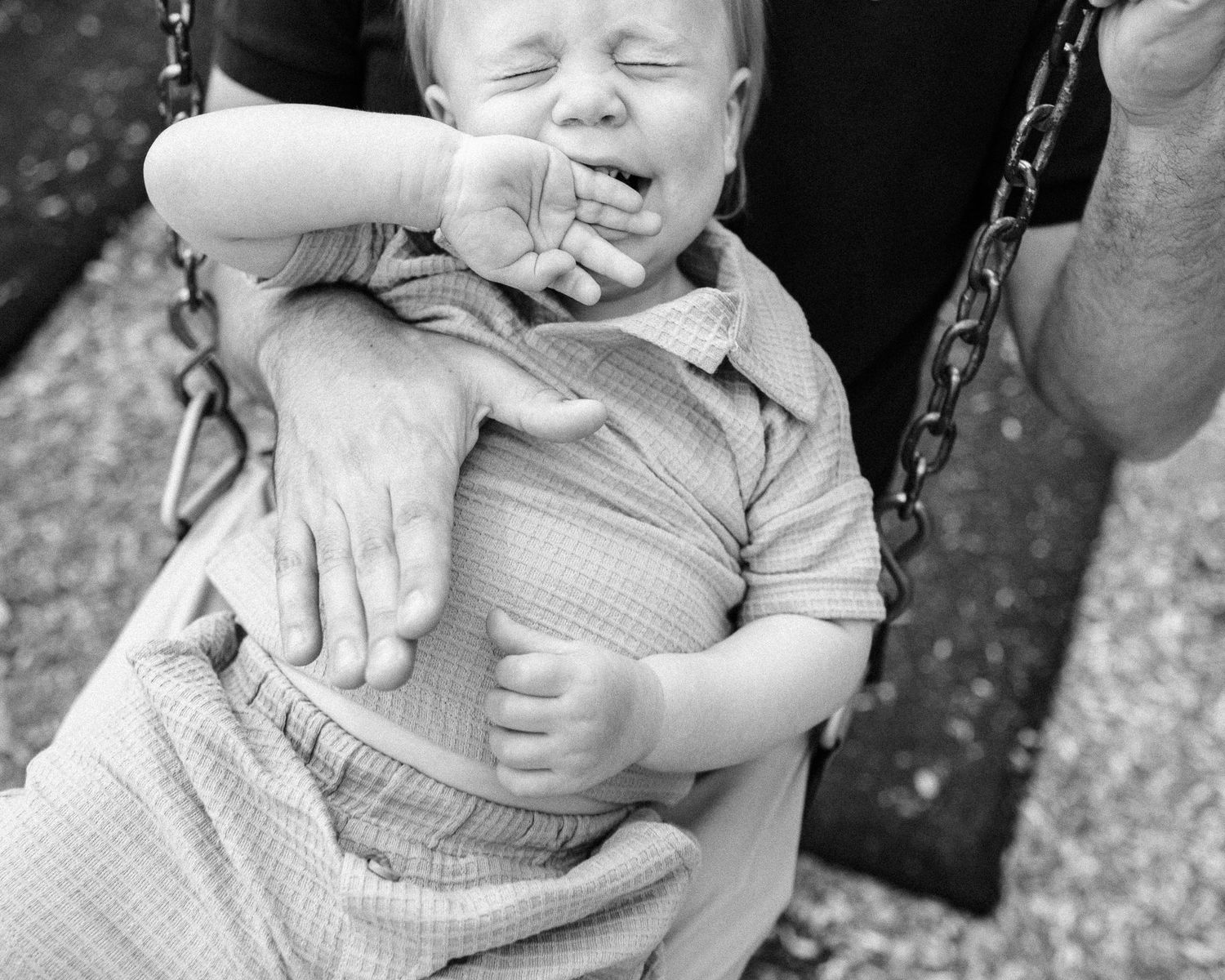 Black and white series showing tender family interactions on outdoor swings.