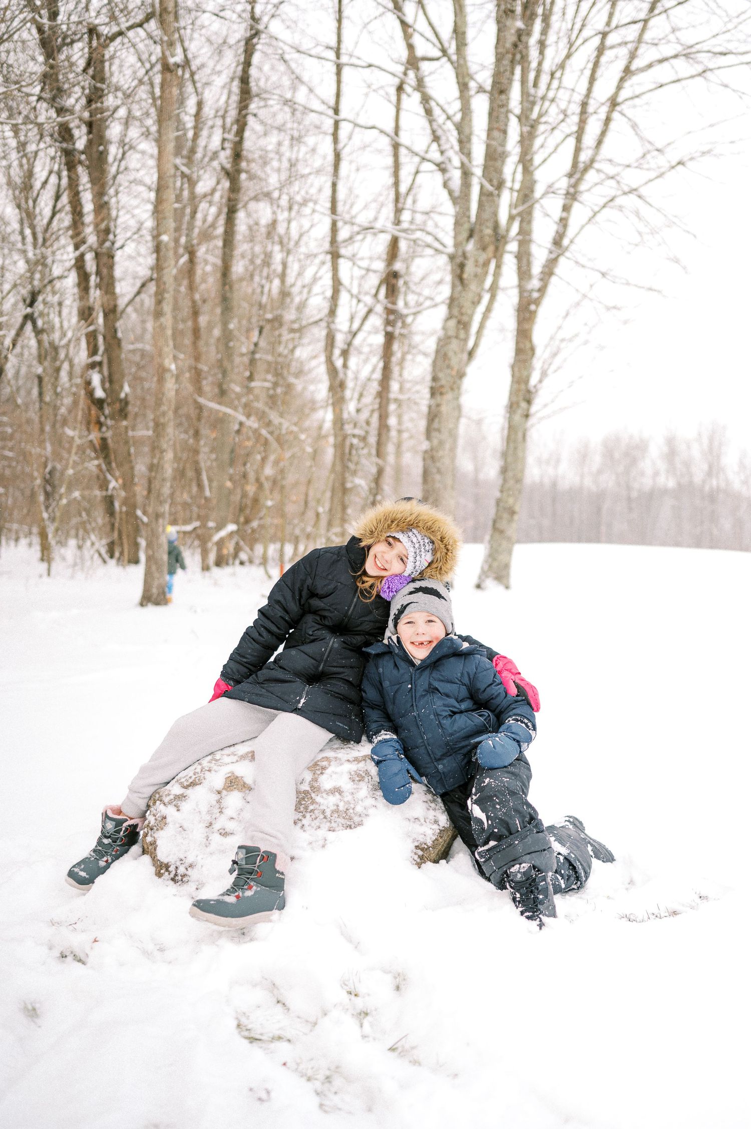 Sequential photos showing someone playing and rolling in deep winter snow.