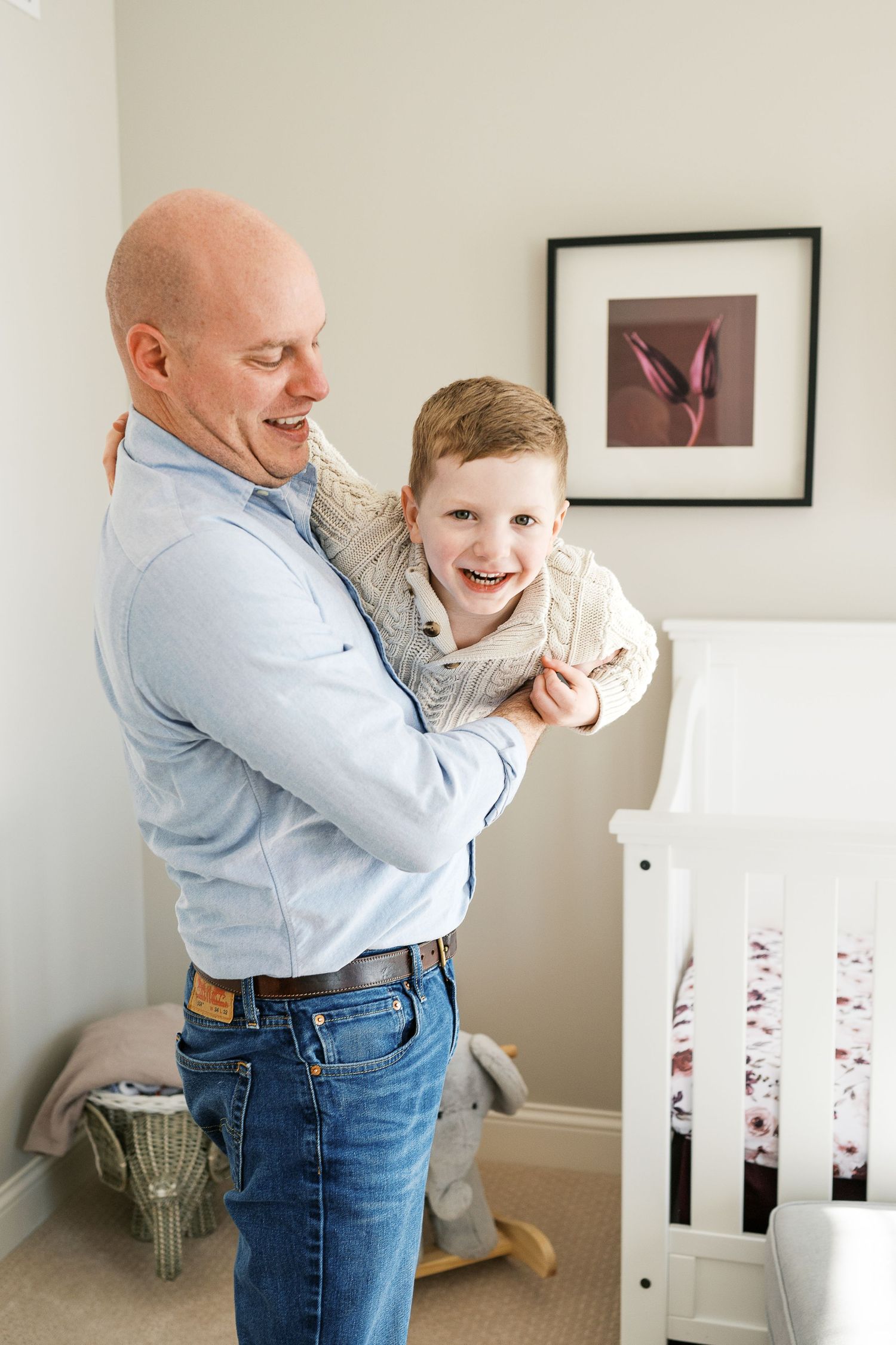 Joyful moment shared between parent and child in front of framed artwork.