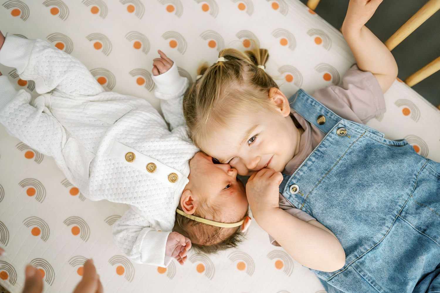 Children resting on polka dot bedding in nursery.