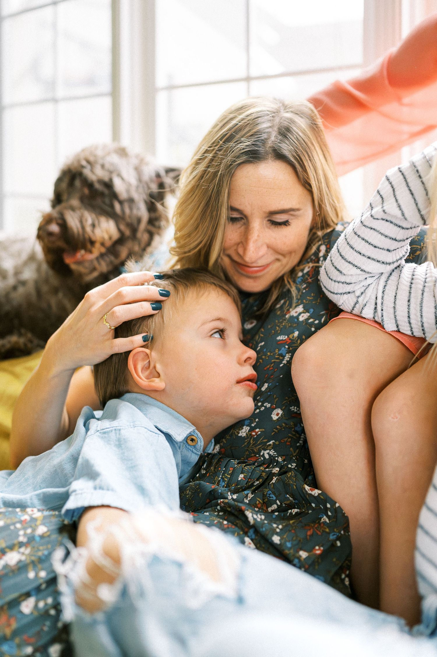 Intimate family bonding moment captured in soft window light.