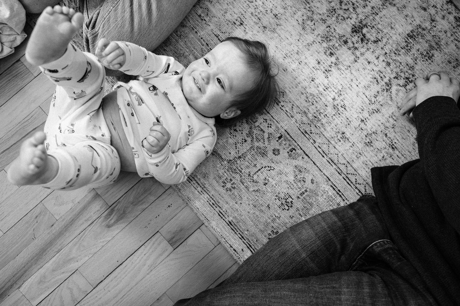 A peaceful moment captured in black and white on hardwood floors with a decorative rug.