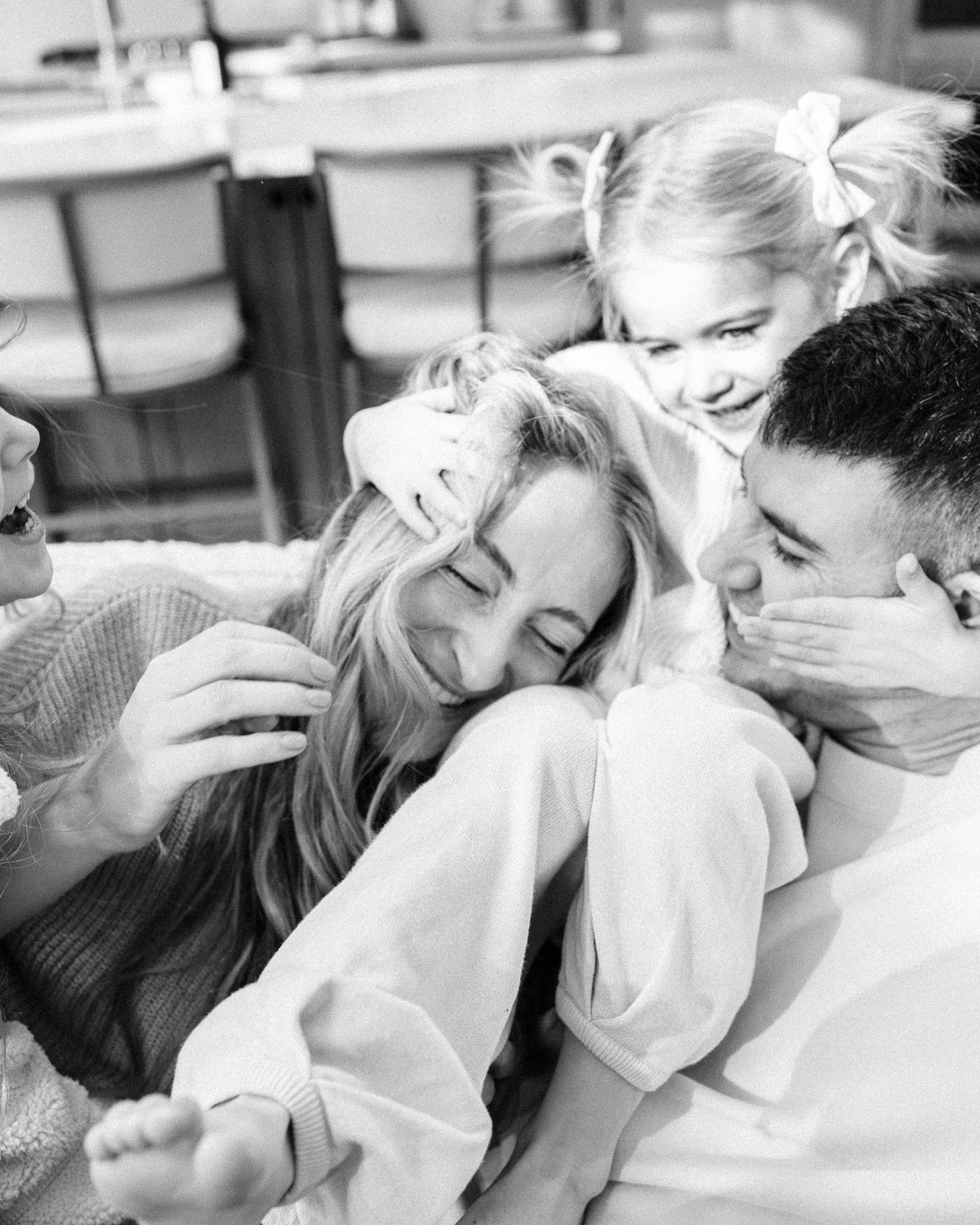 Series of black and white candid photos showing intimate family snuggles and laughter.