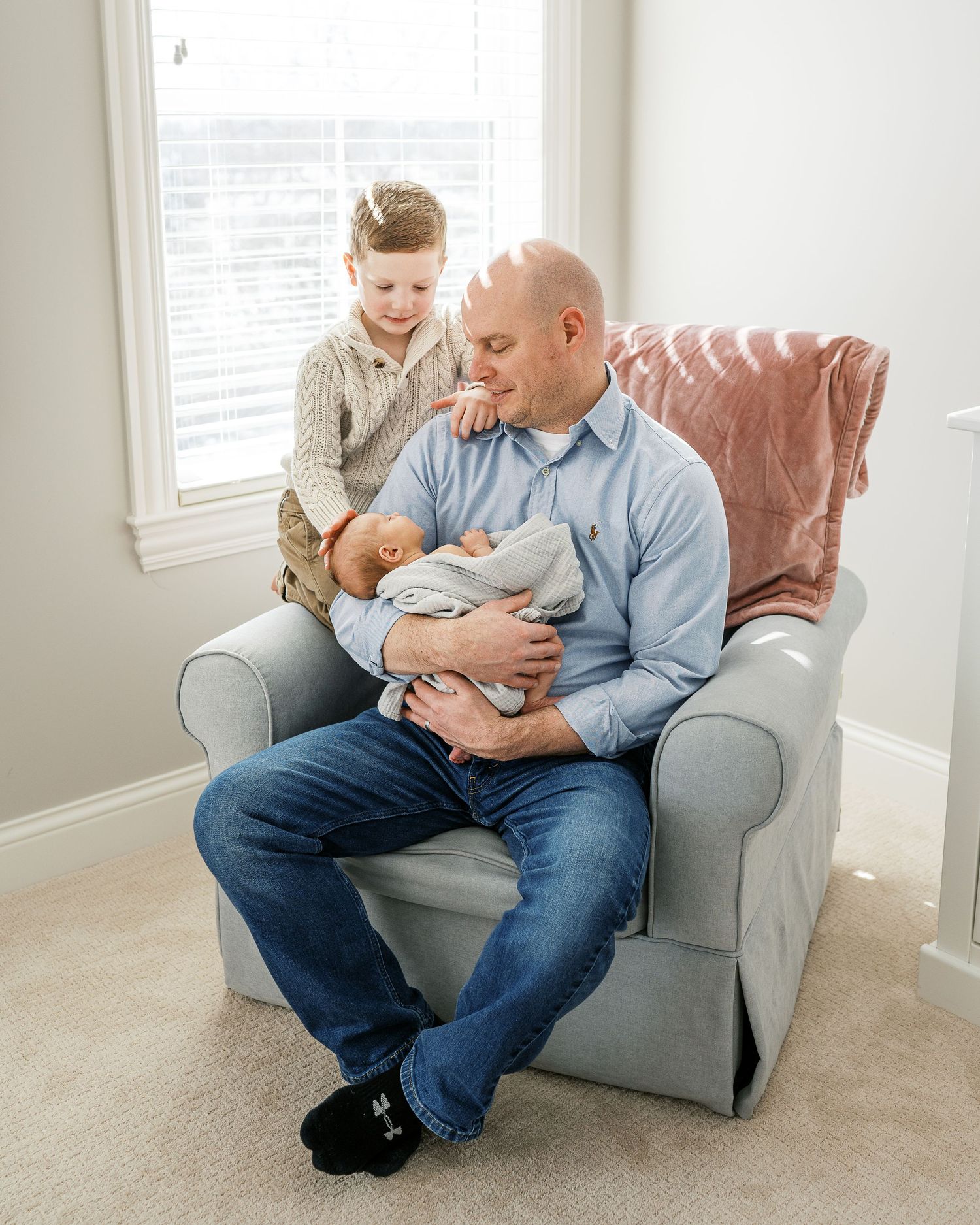 A relaxed scene in a bright living room with comfortable grey armchair and natural lighting.