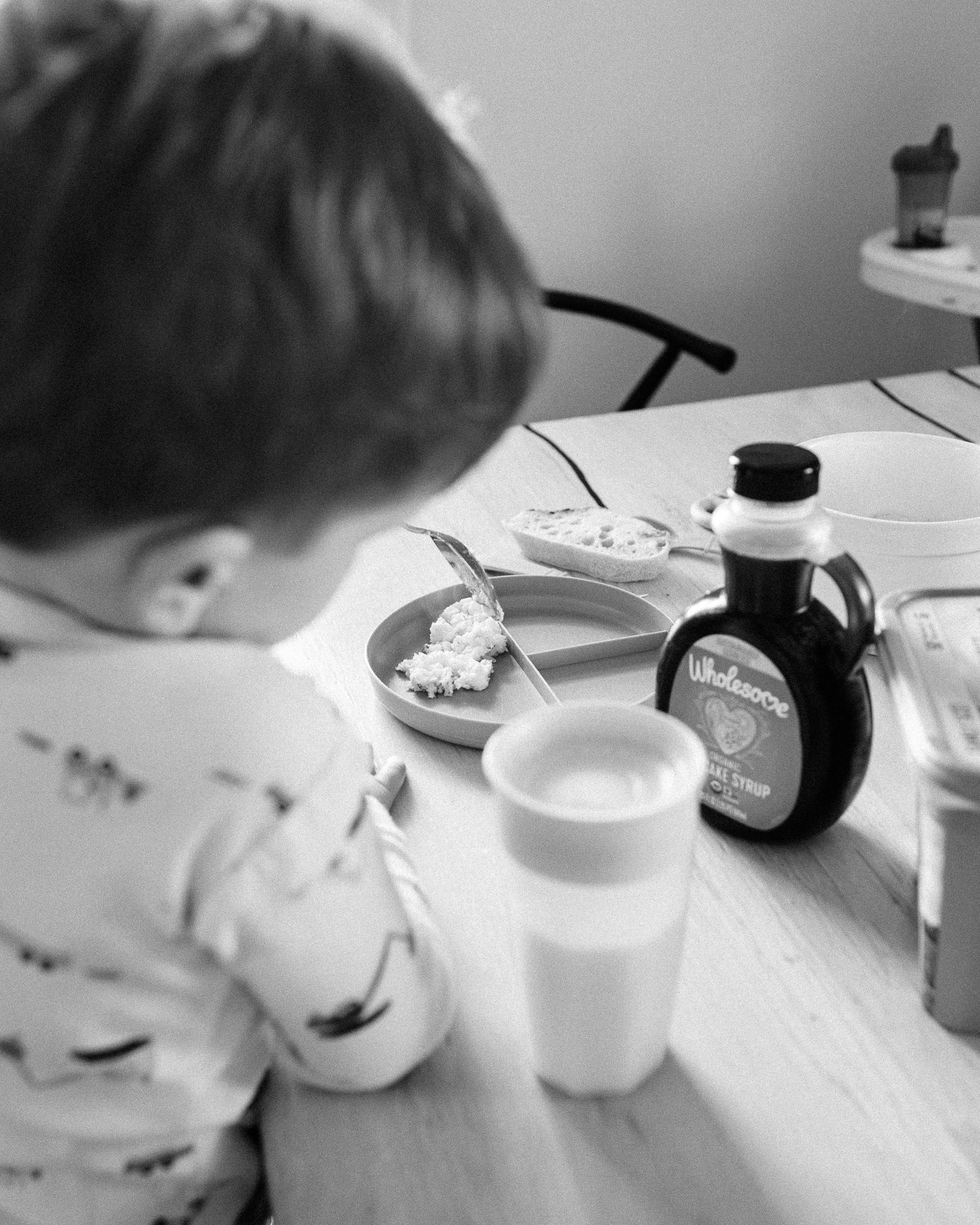 A sequence of black and white images showing a child's hands reaching for items on a kitchen table.