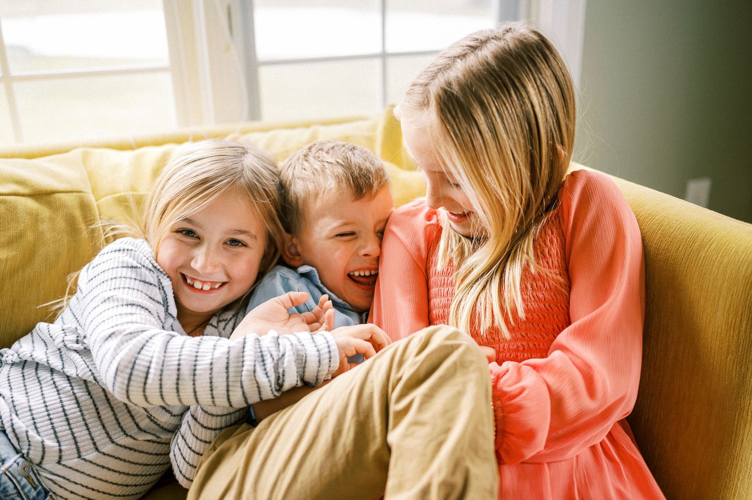A series of candid moments showing affection and laughter on a yellow couch.
