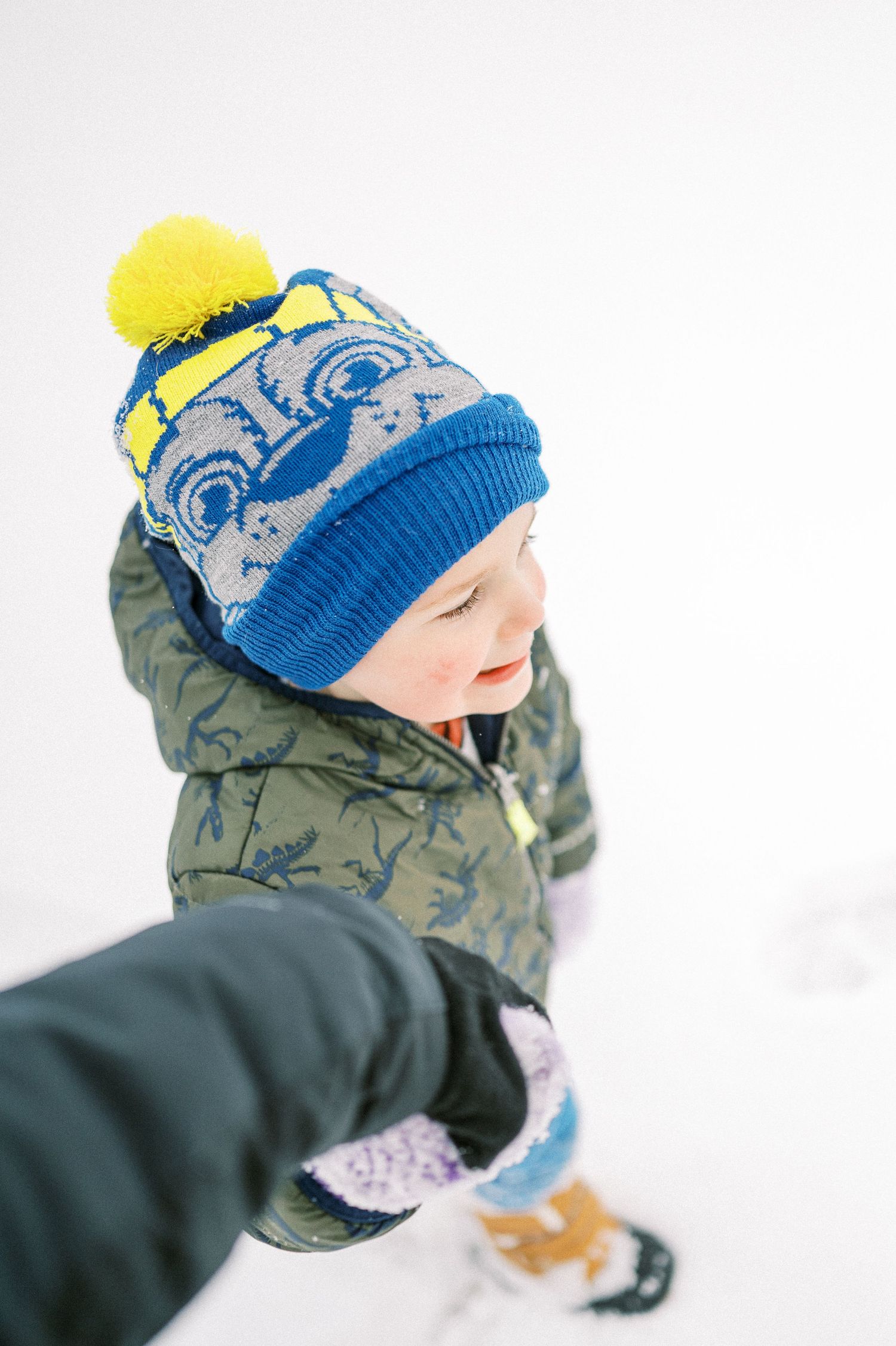 Winter fun with someone wearing a blue and yellow knit hat in the snow.