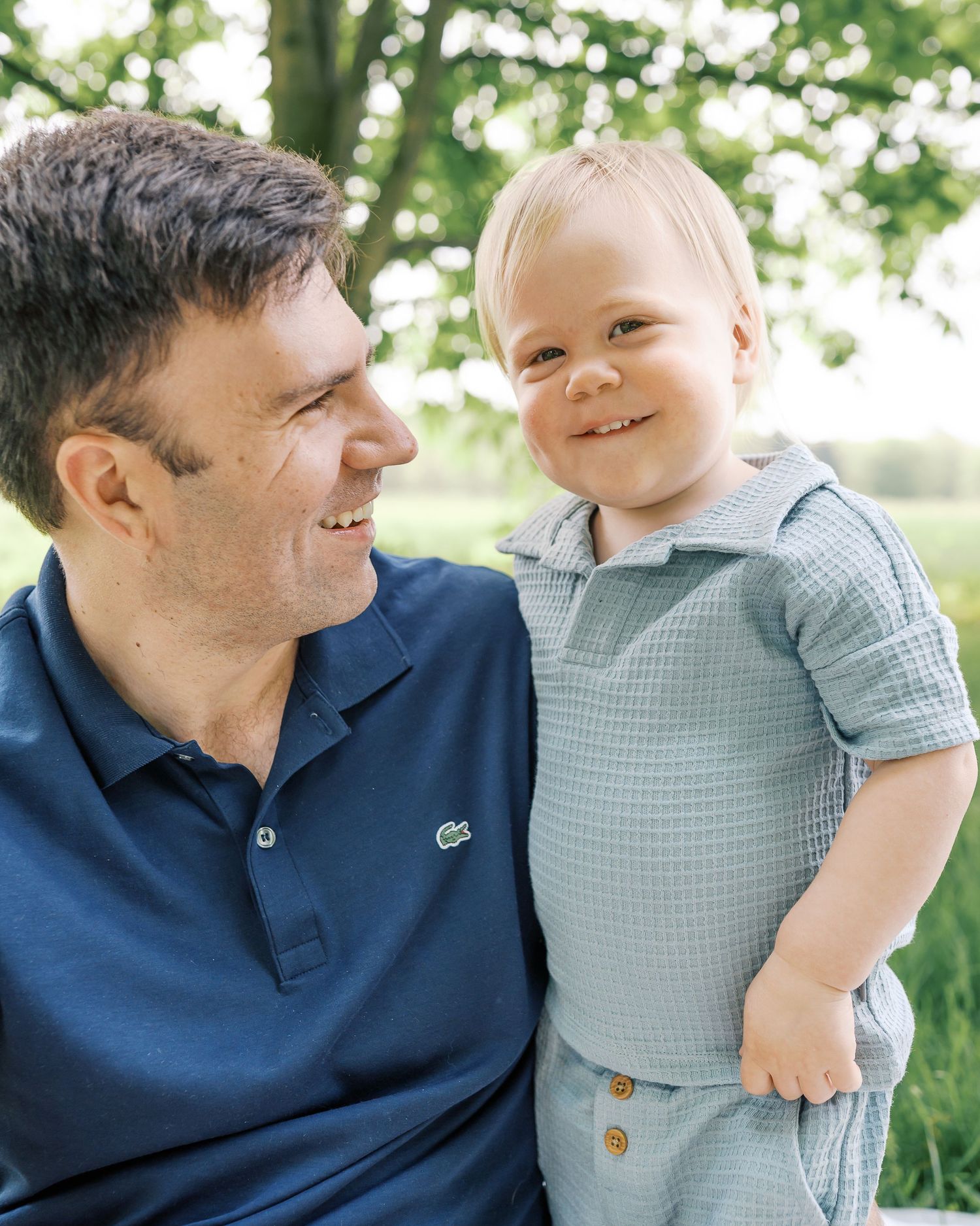 A tender outdoor portrait of parent and child sharing a joyful moment.