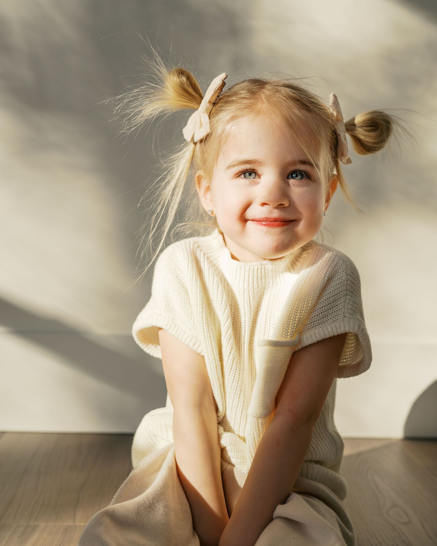 Soft natural lighting illuminates playful poses on hardwood flooring.