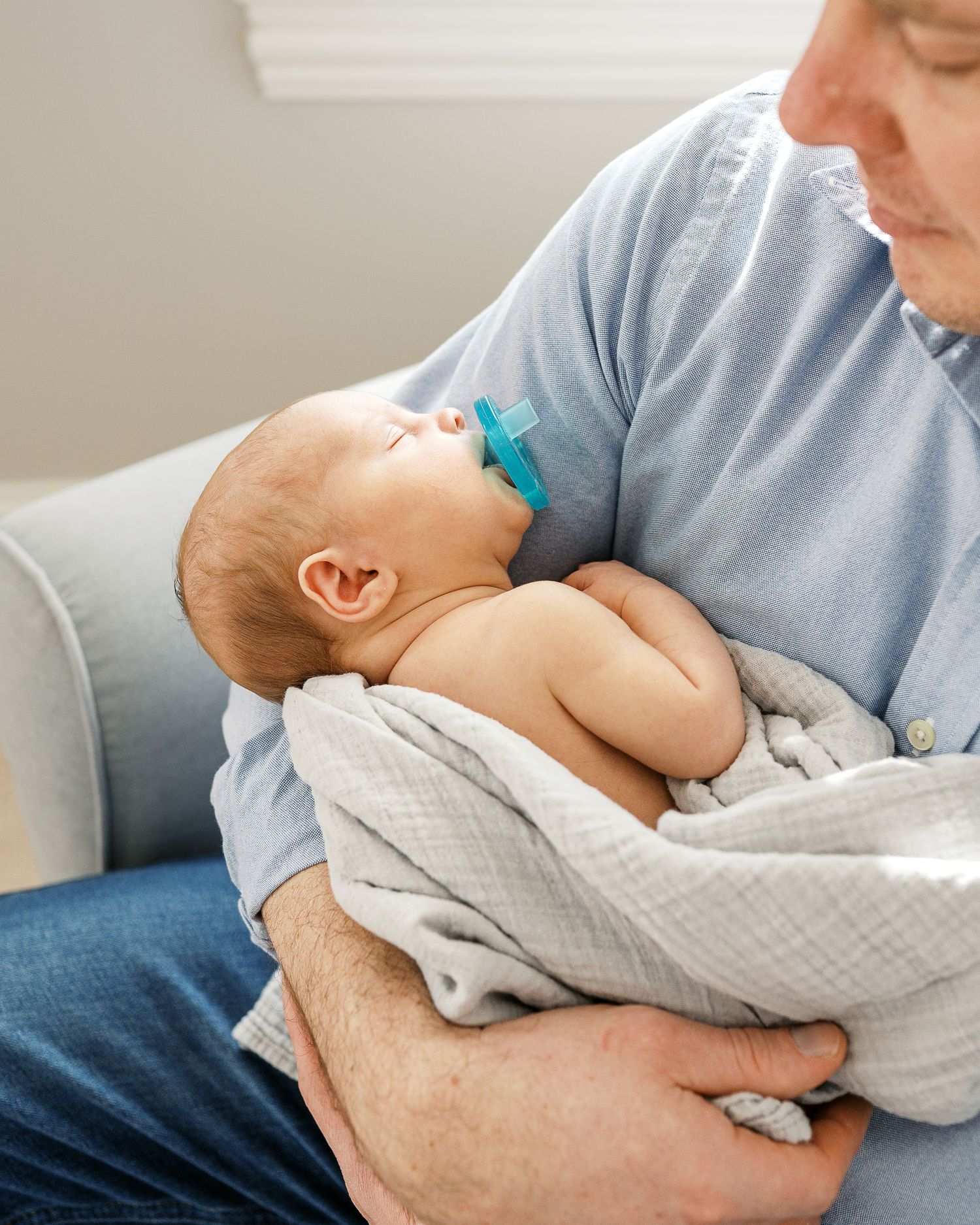 A tender moment between a parent and infant in a series of touching close-up shots.
