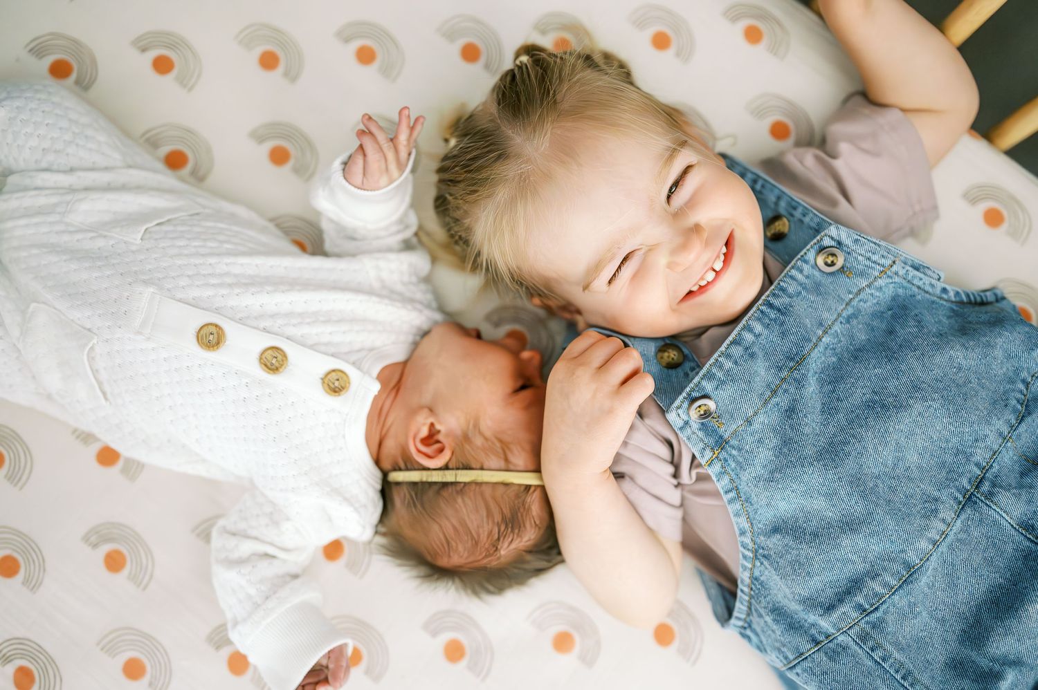 Children resting on polka dot patterned bedding in soft lighting.