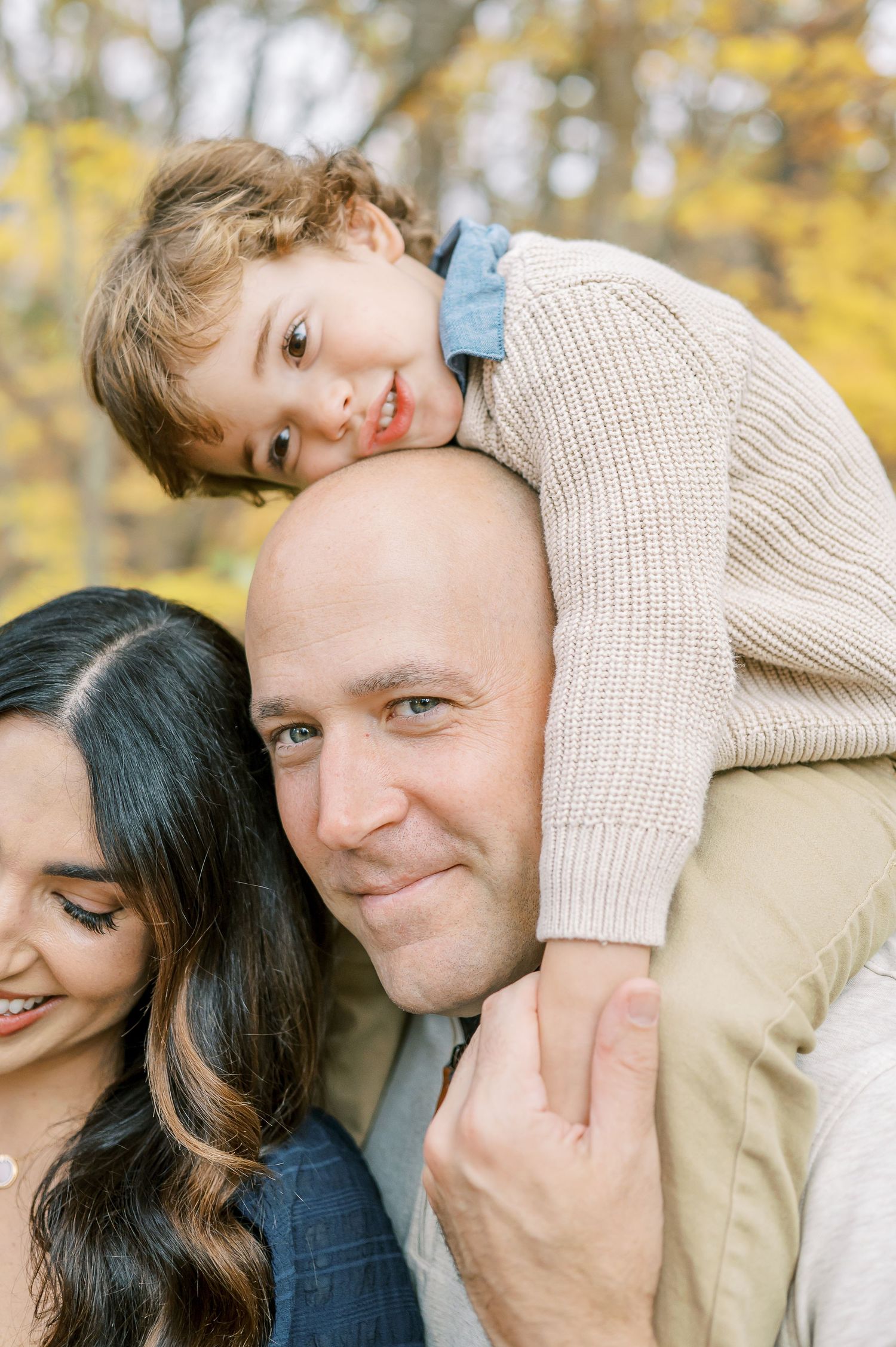 Intimate close-up moments of family members sharing affection during fall photo session.