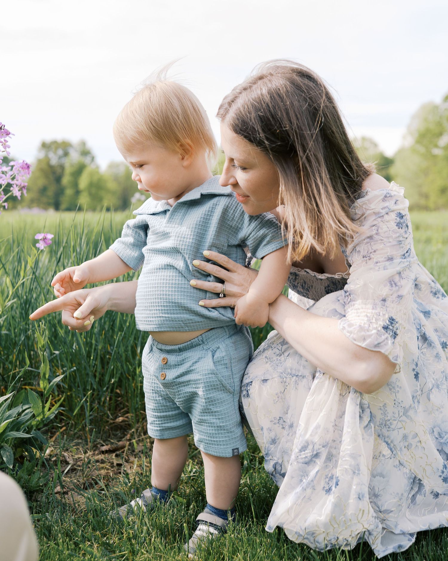 Family enjoying a summer day among wildflowers in a grassy meadow.