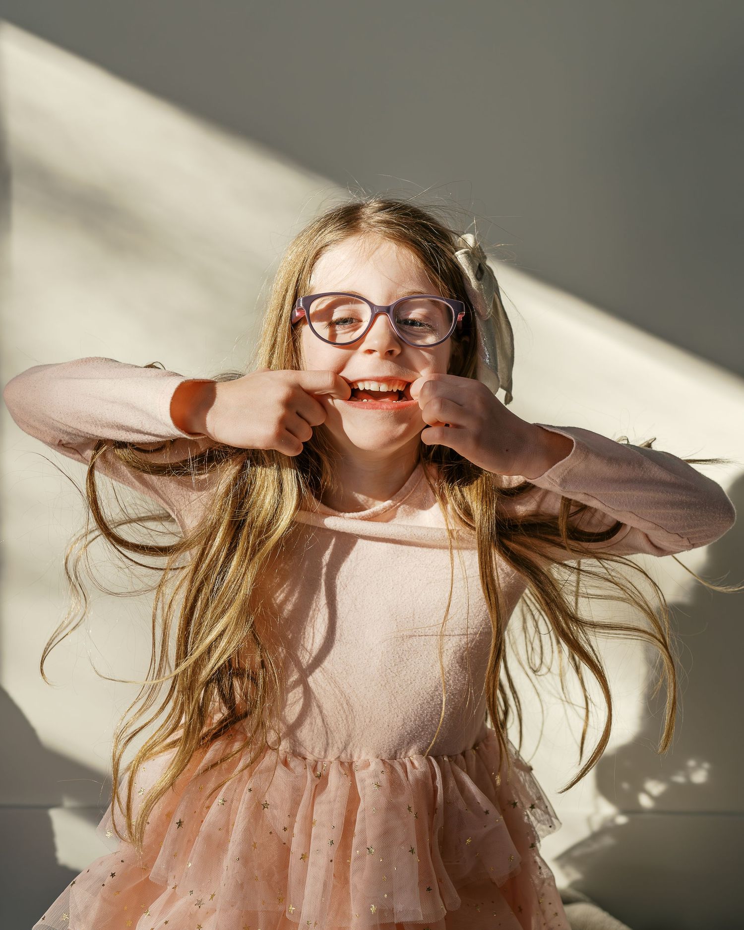 Sunlit portrait session showing expressions of joy and playfulness.