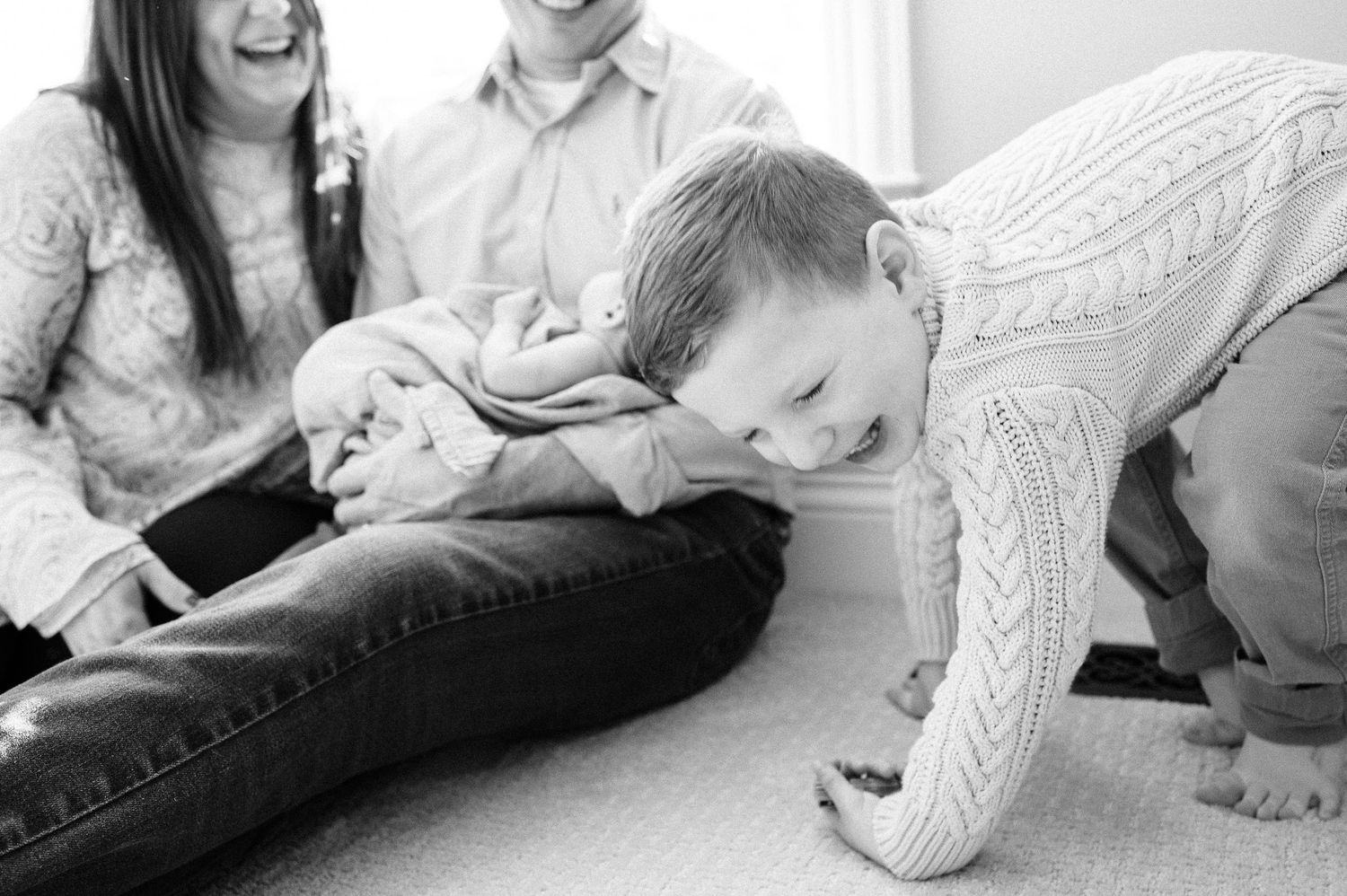 A sweet family moment captured in black and white as they bond with their newborn.