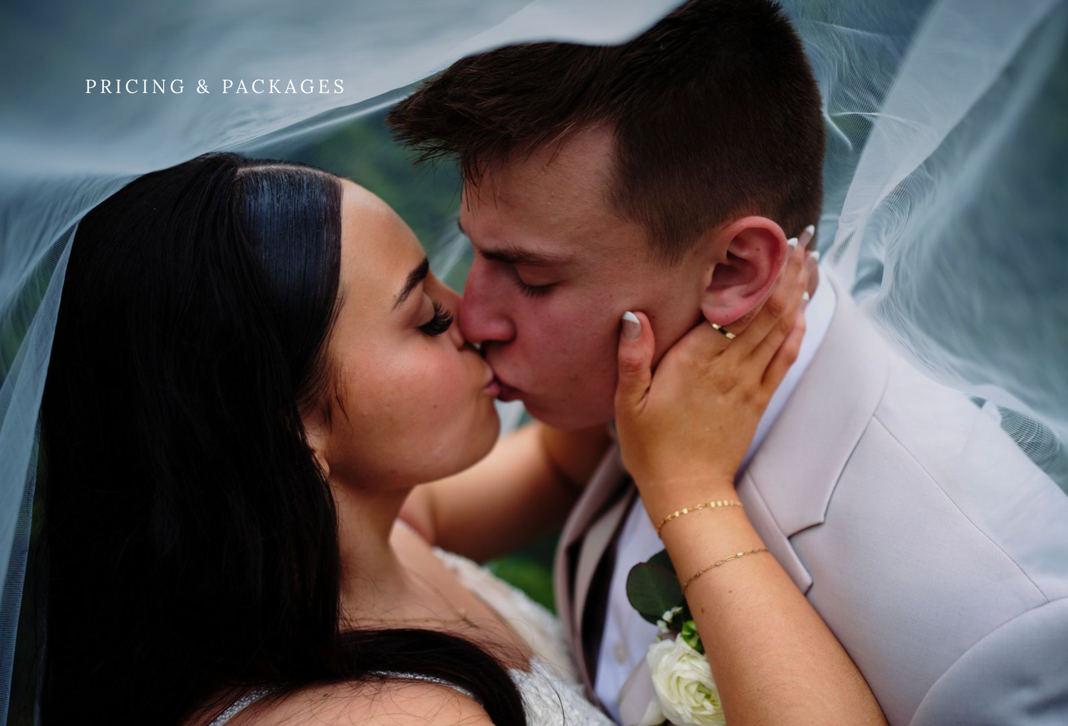 Romantic portrait of couple kissing under wedding veil at The Tannery Barn in Mount Airy, Maryland.