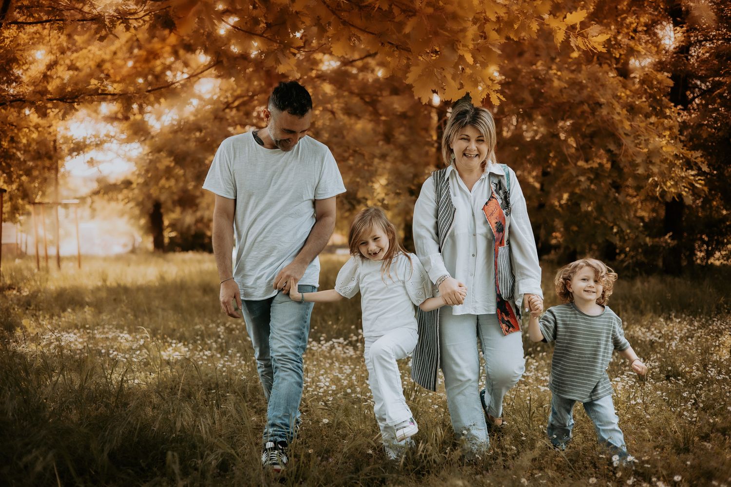Famiglia che cammina insieme in un parco. Servizio fotografico di famiglia all’aperto a Milano, stile naturale e spontaneo.