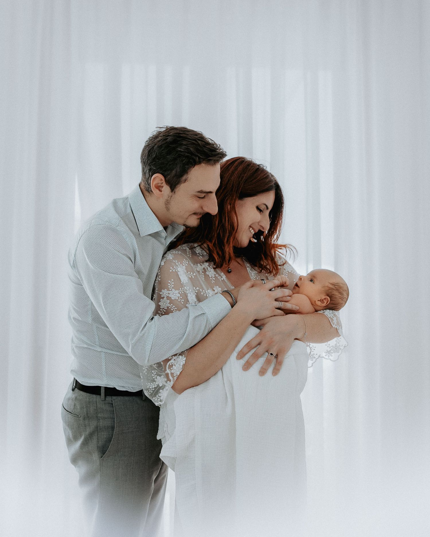 fotografa Newborn Milano est mentre i genitori coccolano il loro figlio.