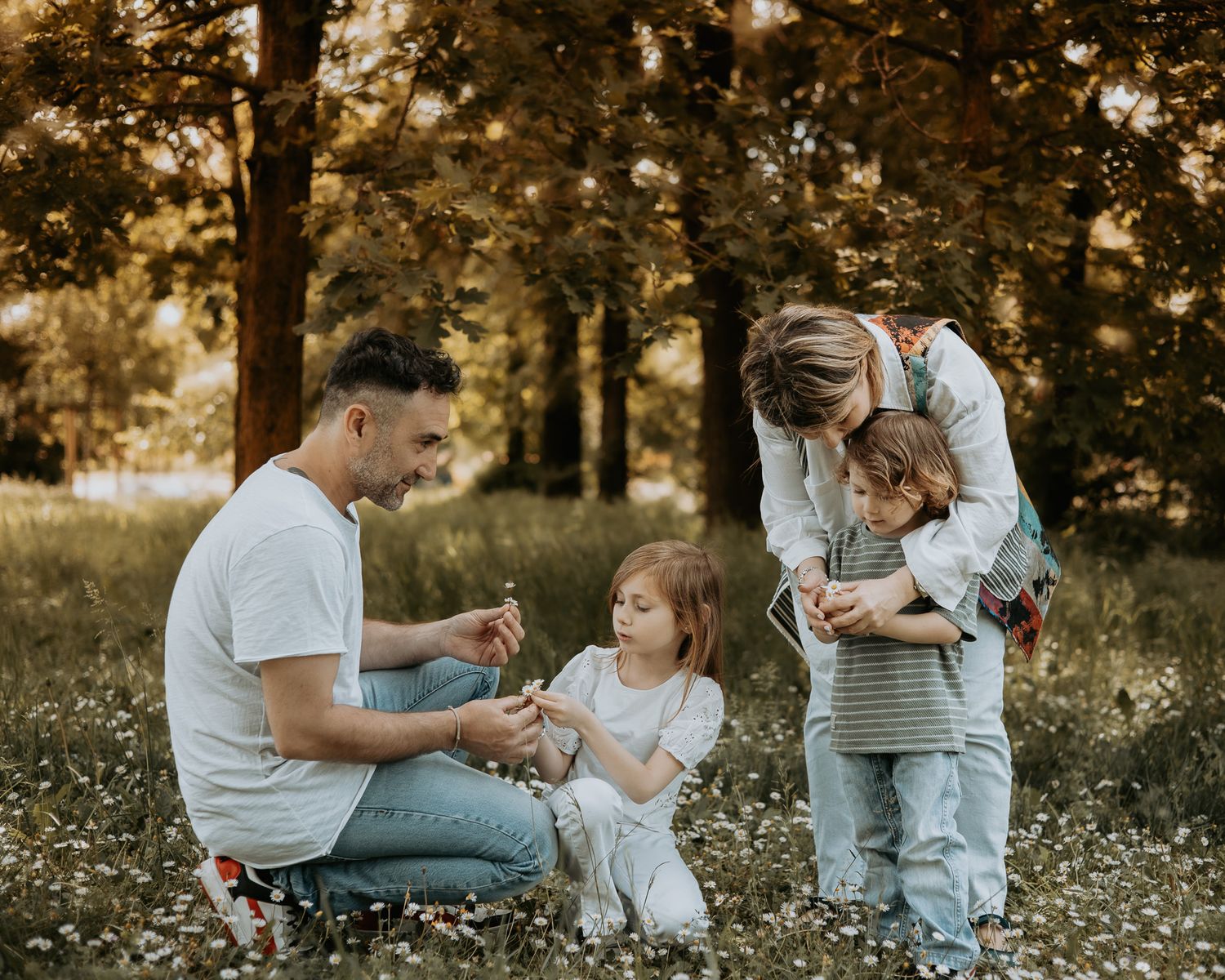 Candid family photos taken in a field with golden hour lighting.