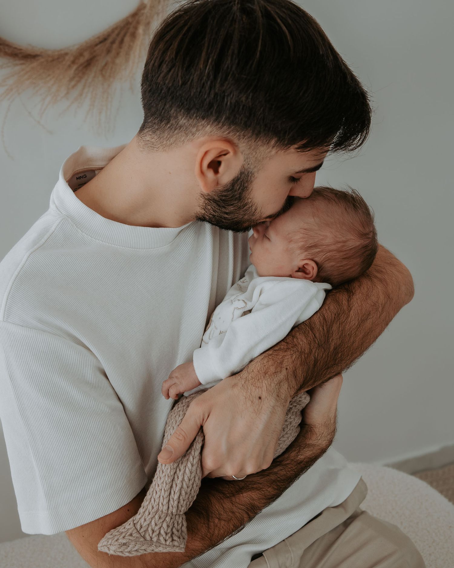 Papà tiene in braccio il suo neonato con dolcezza.