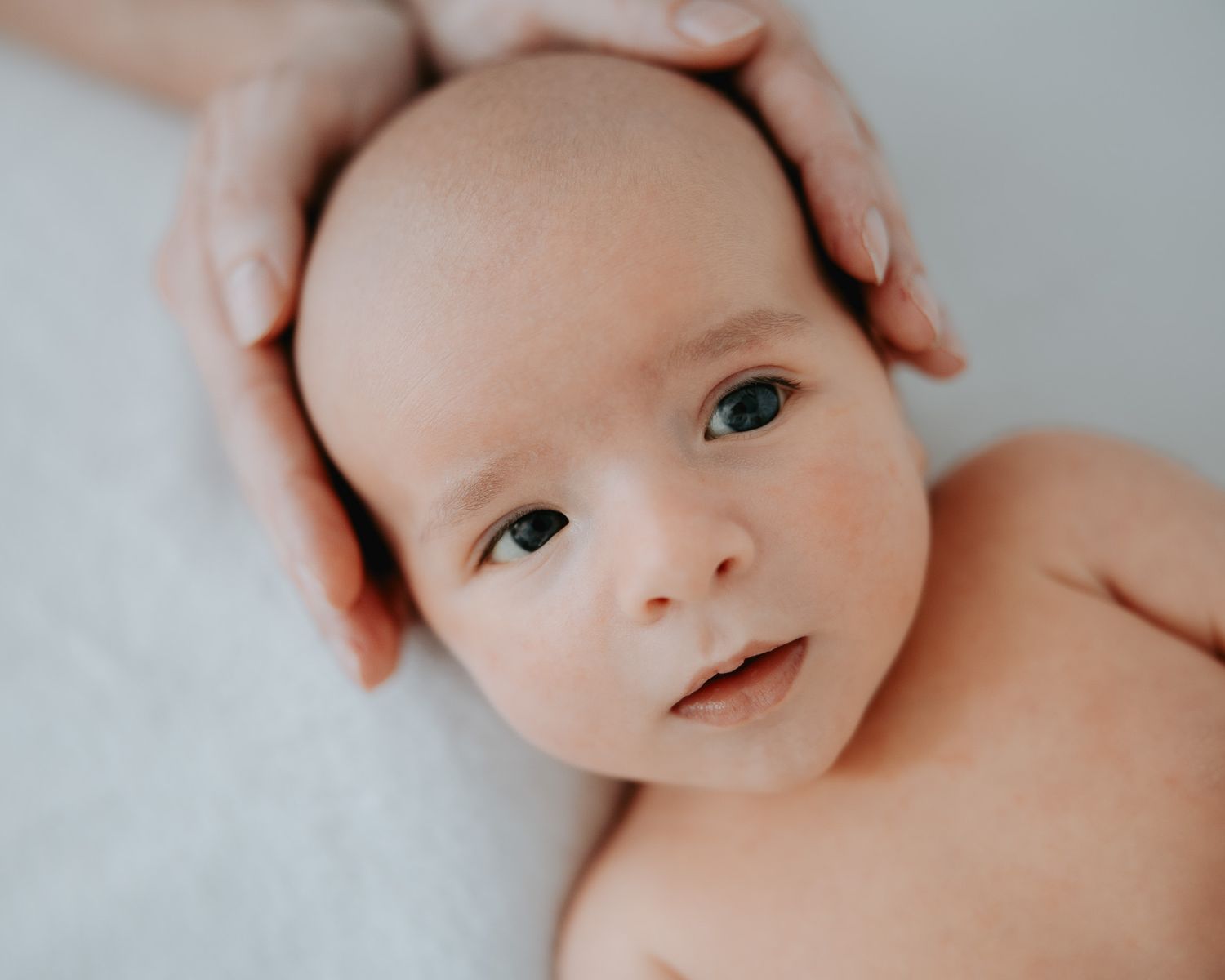 Primo piano del viso del neonato con occhi aperti.