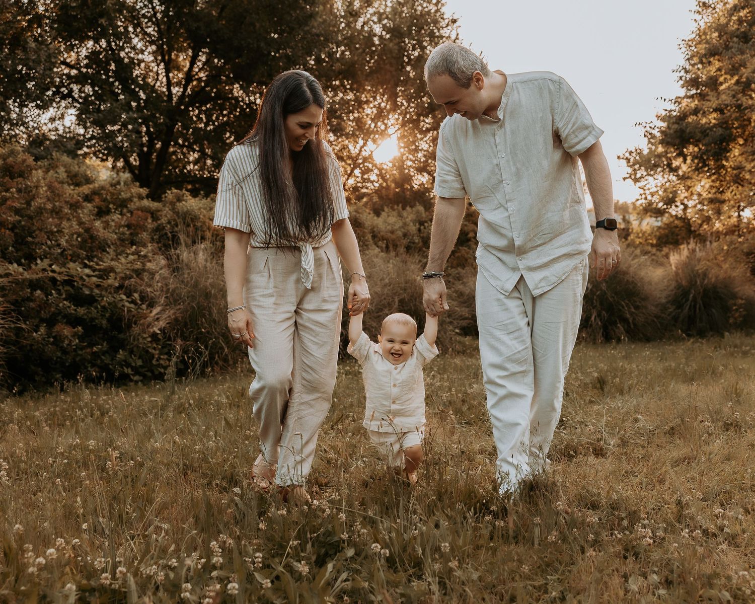 Bambino di un anno che muove i primi passi durante un servizio fotografico di primo compleanno all’aperto