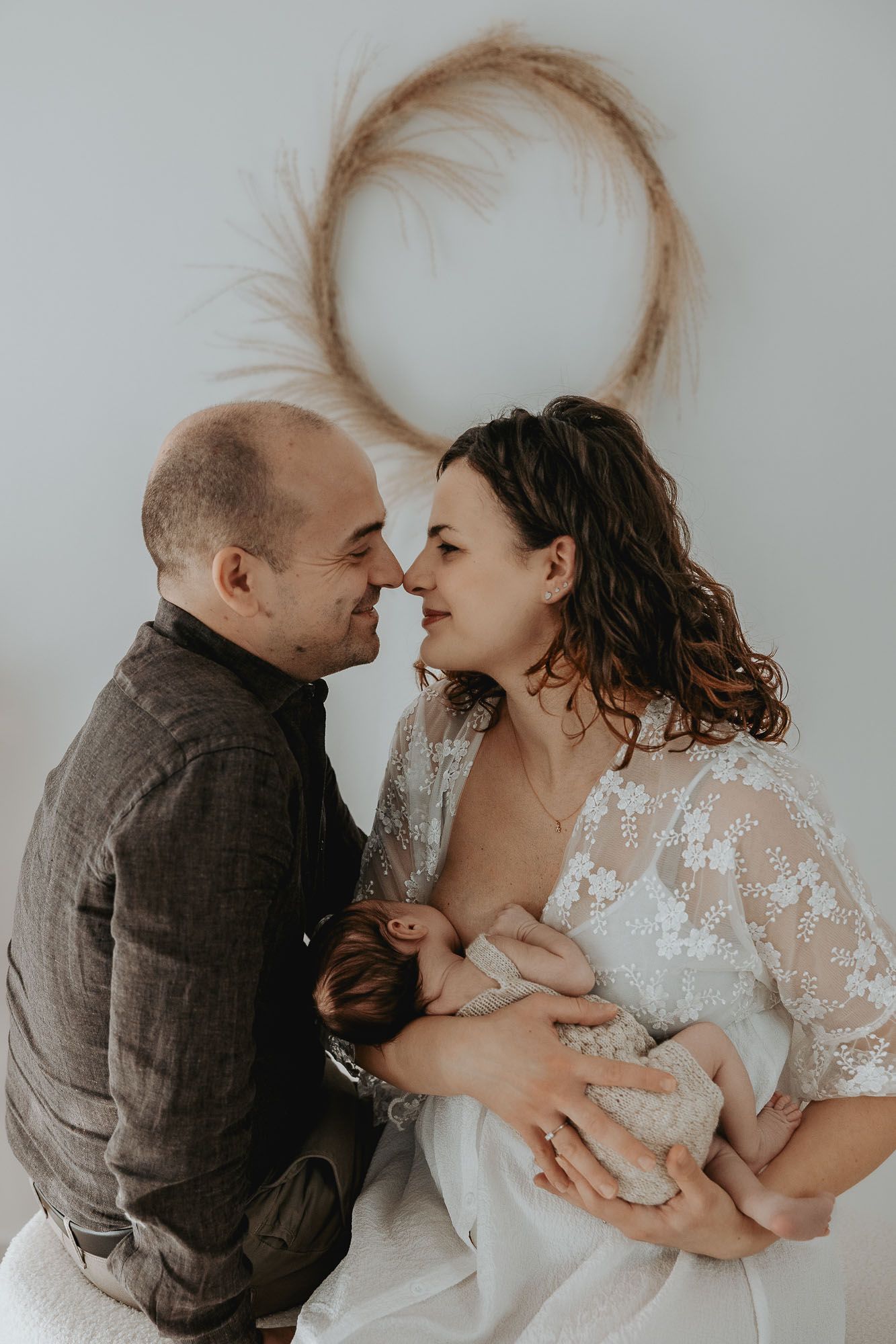 Genitori osservano con amore il loro neonato.