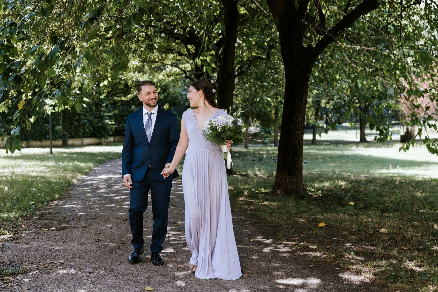 A couple shares a tender moment together in a wooded outdoor setting during a special celebration.