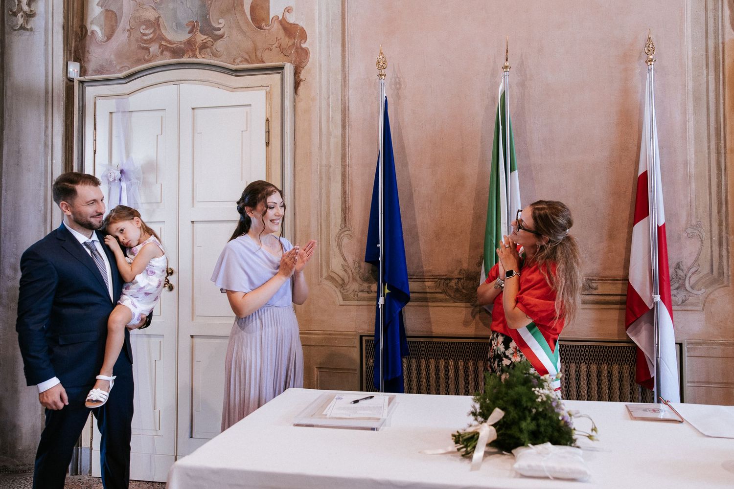 A sequence of five wedding ceremony photos showing document signing and celebration moments in an elegant room.