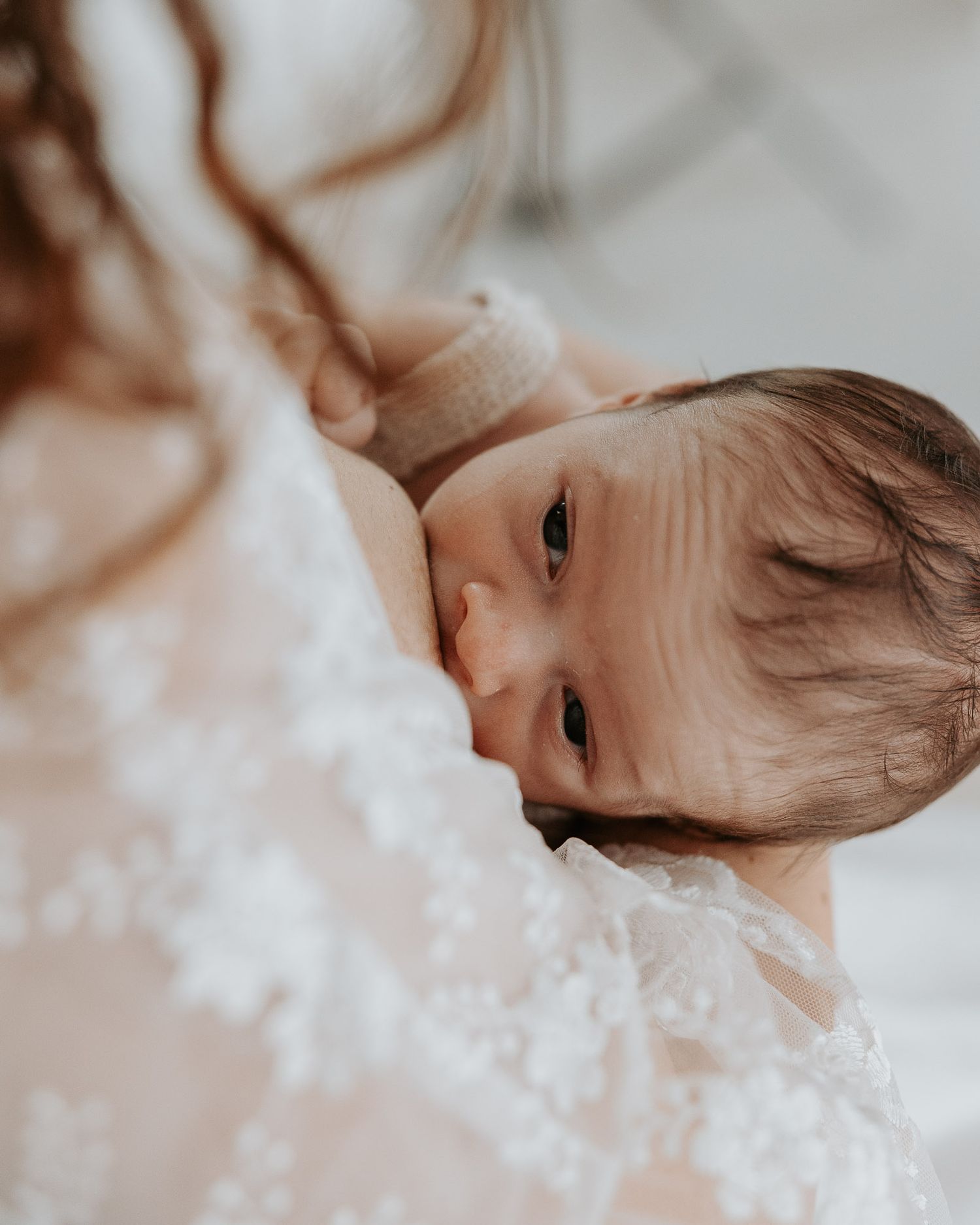 Neonato che guarda la mamma durante l’allattamento.