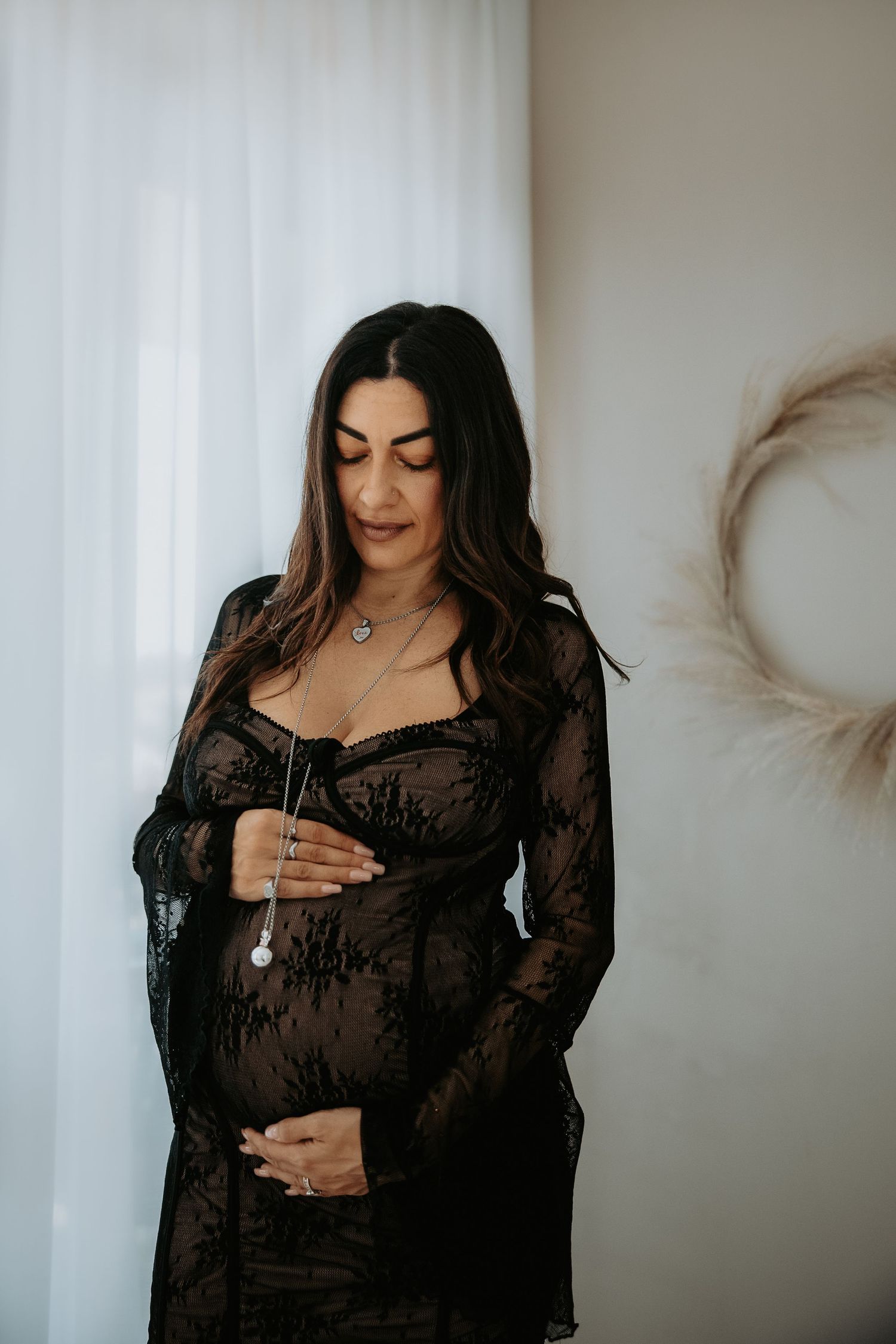 Ritratto maternity elegante in studio a Milano con abito nero trasparente