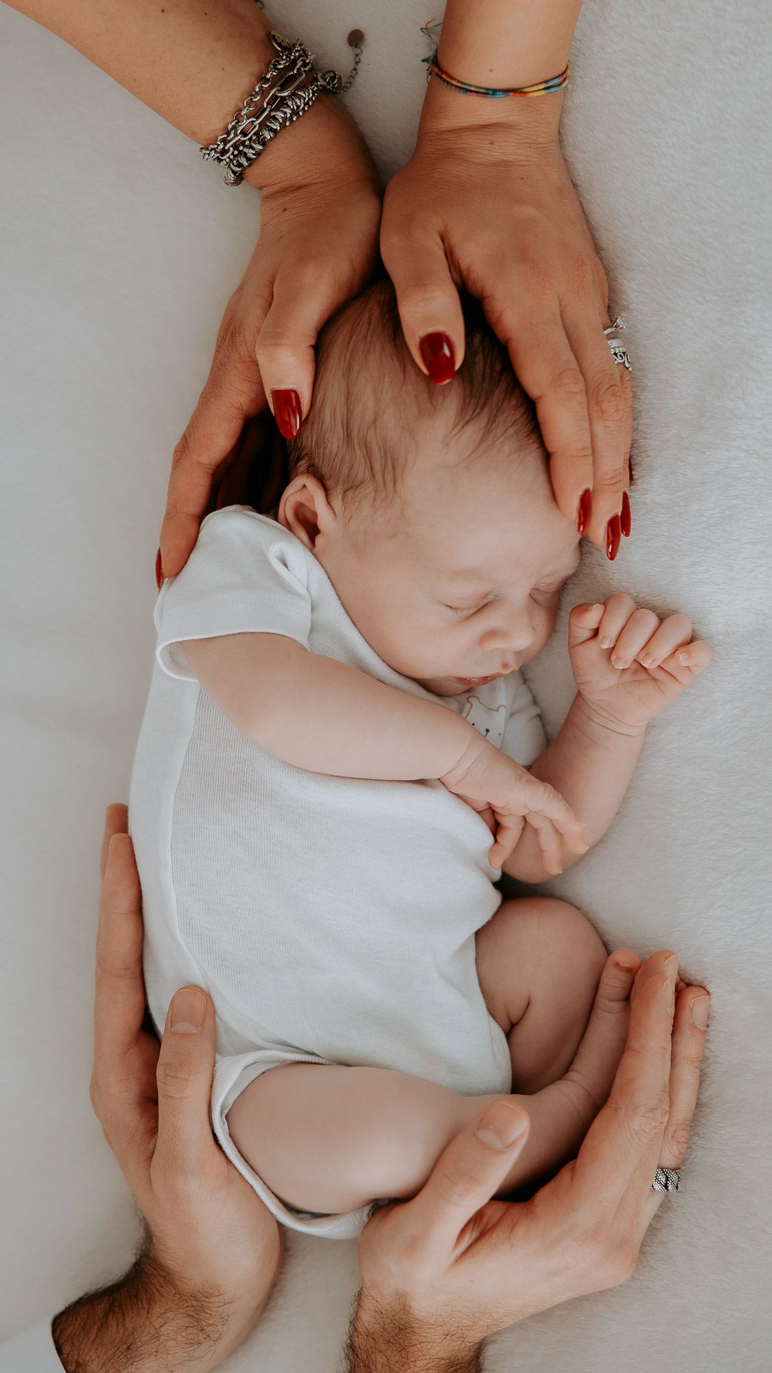 Mani dei genitori che proteggono il neonato