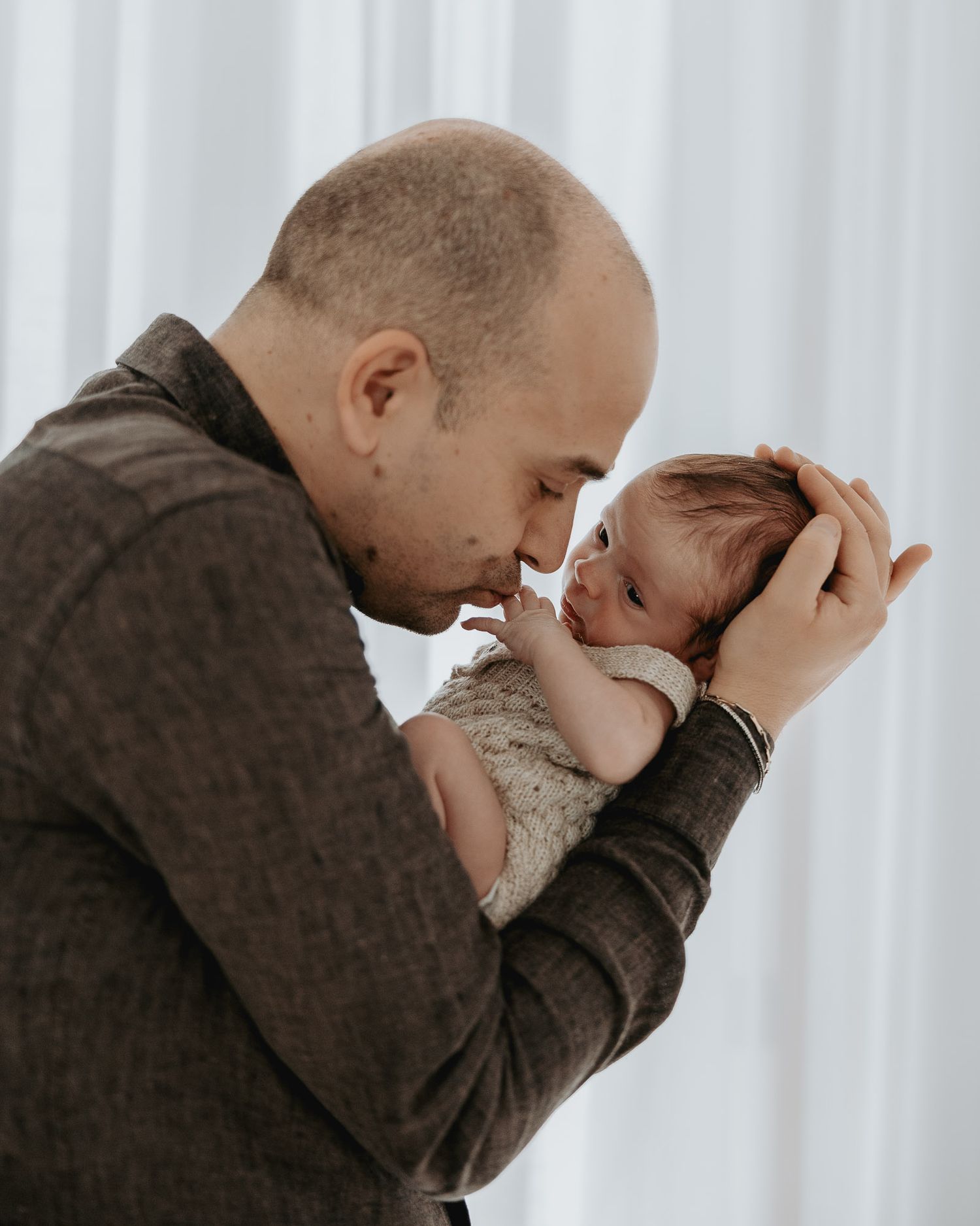 Papà avvicina la fronte a quella del neonato.