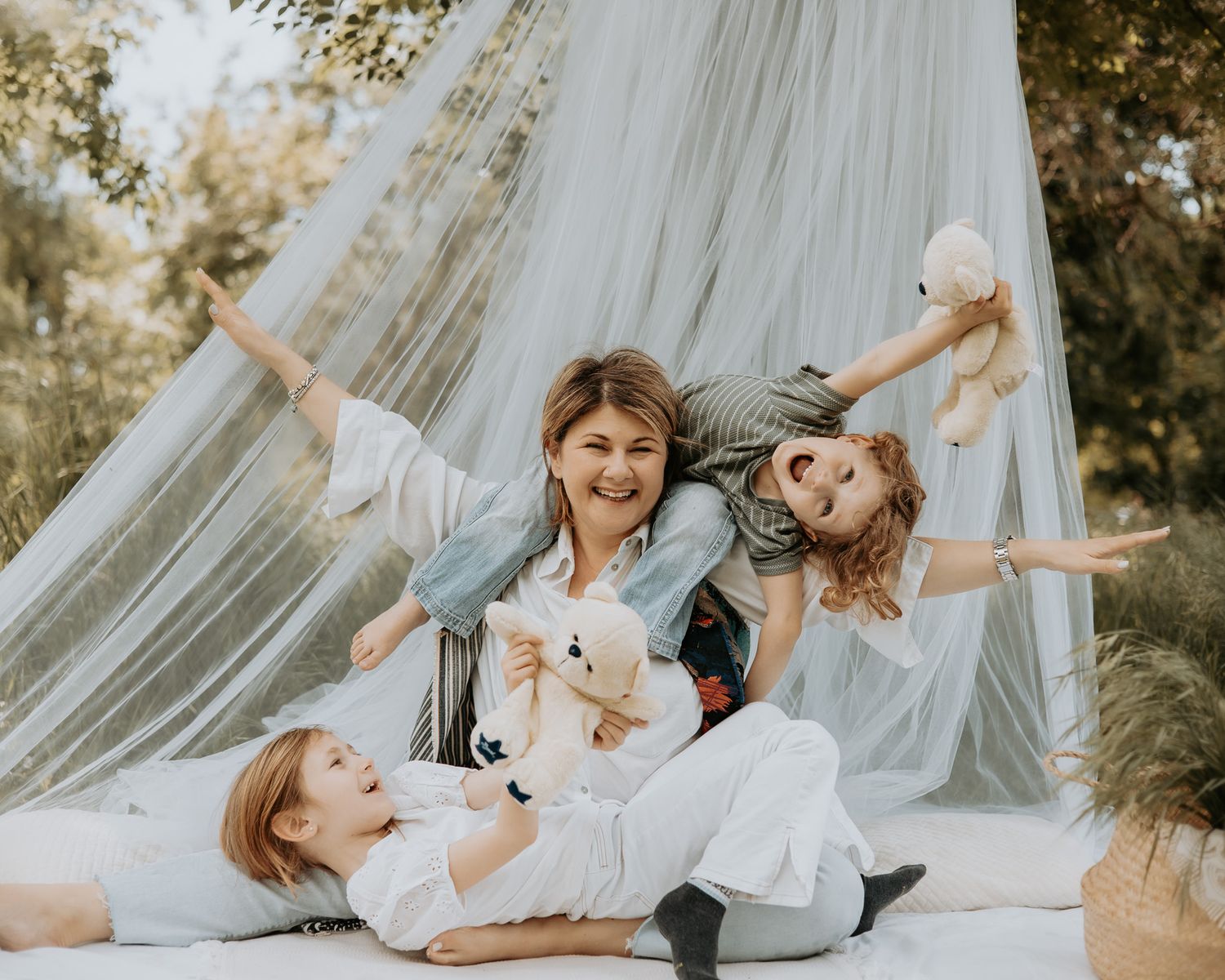 Joyful family lifestyle session with white draping backdrop outdoors.