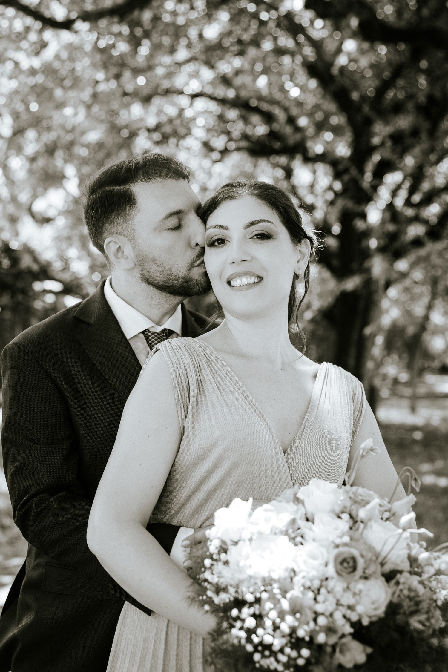 A romantic series of black and white wedding photos showing tender moments between newlyweds with white floral bouquets.