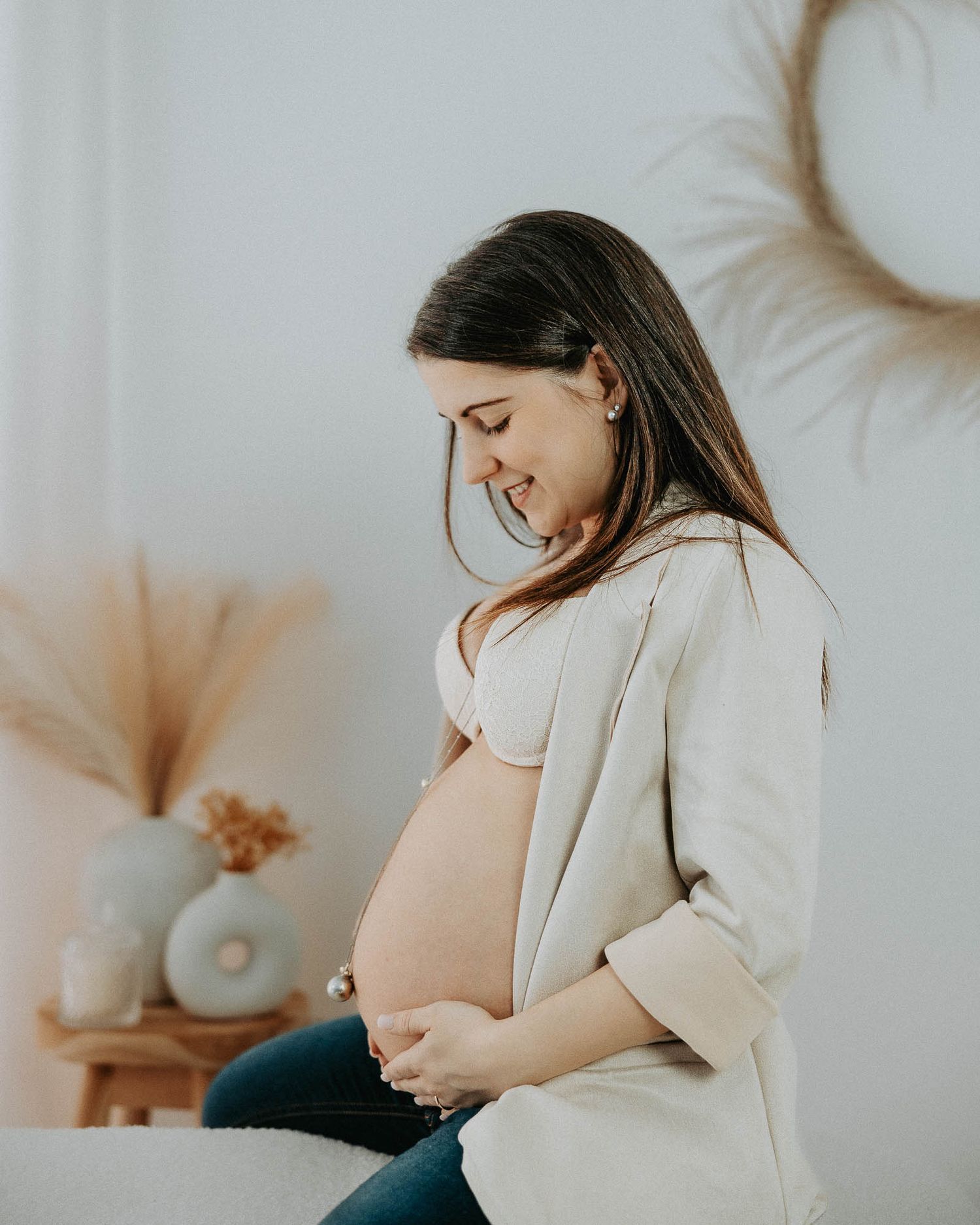 Donna incinta sorridente durante servizio fotografico maternity in studio a Milano zona Rubattino