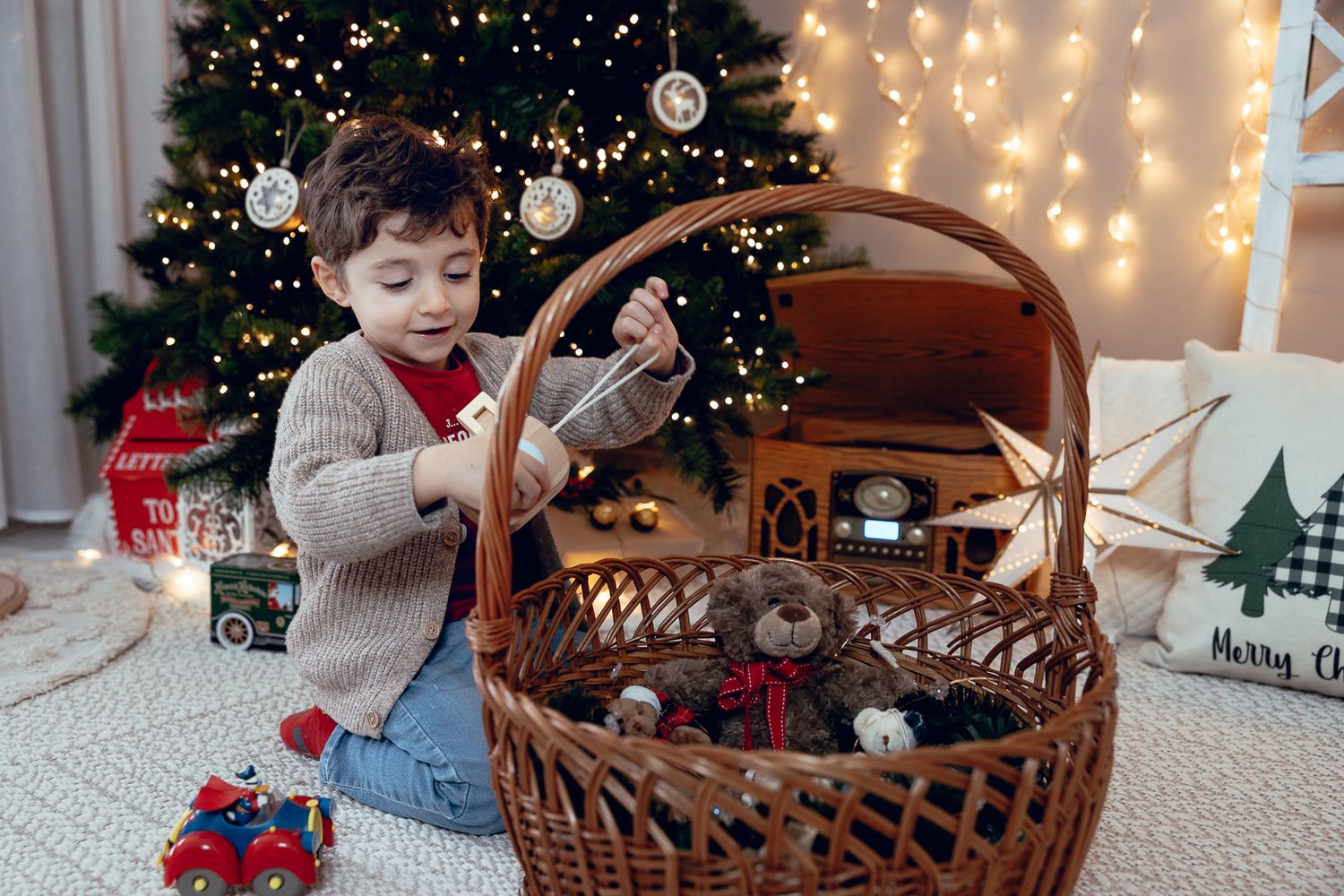 Family Christmas photos with wicker basket props and decorated tree background.