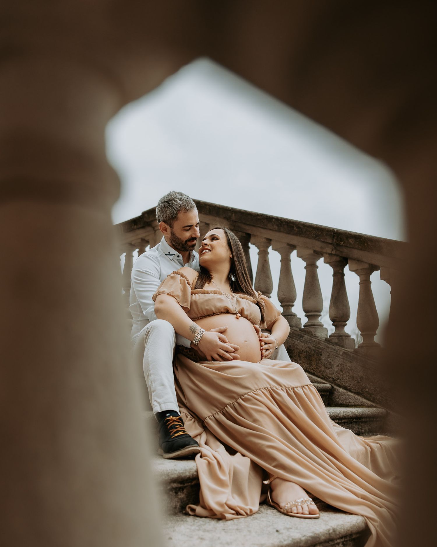 Coppia in attesa seduti sulle scale villa reale durante shooting maternity romantico in villa reale a Monza
