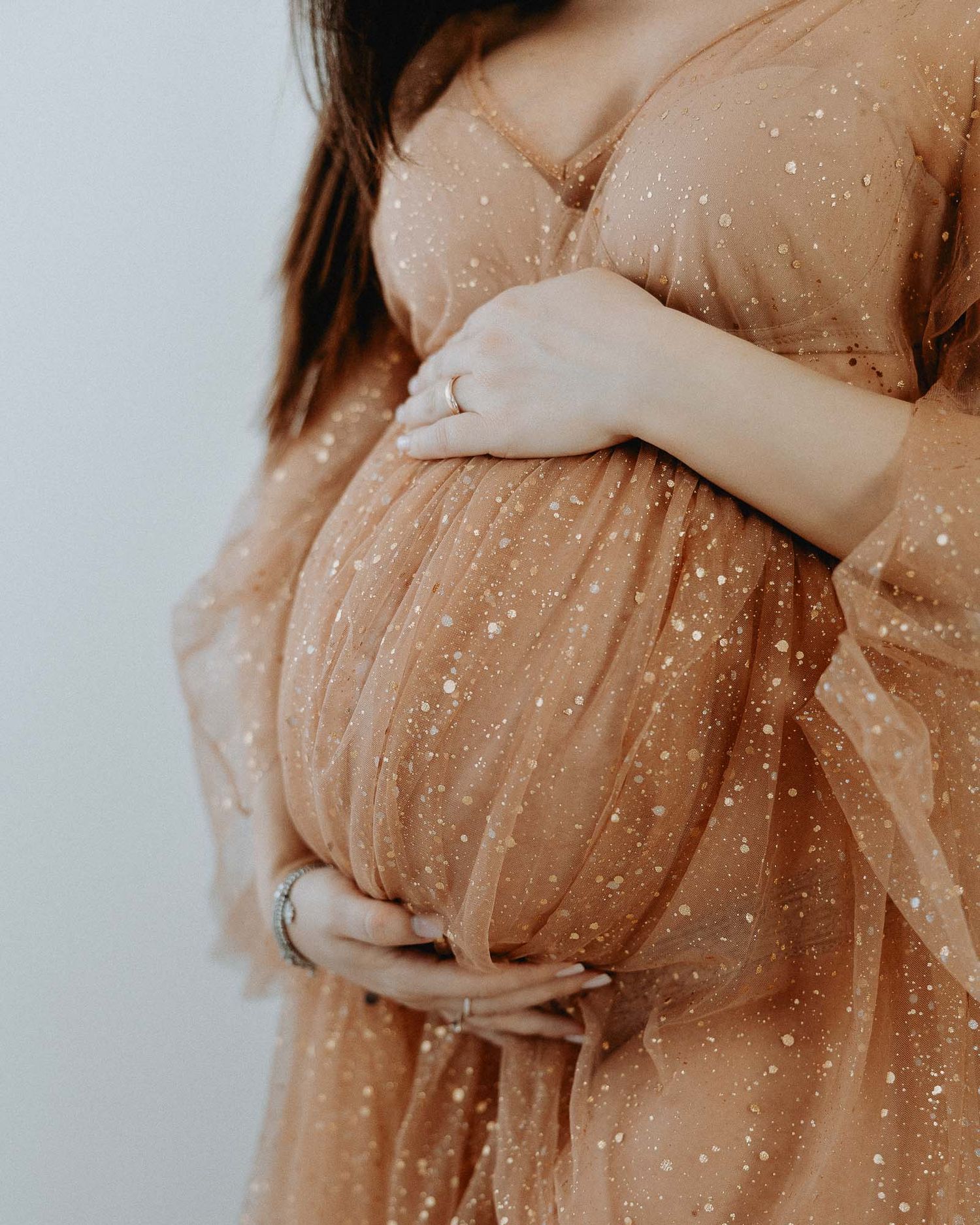 Dettaglio pancione gravidanza con abito glitter durante shooting maternity a Milano