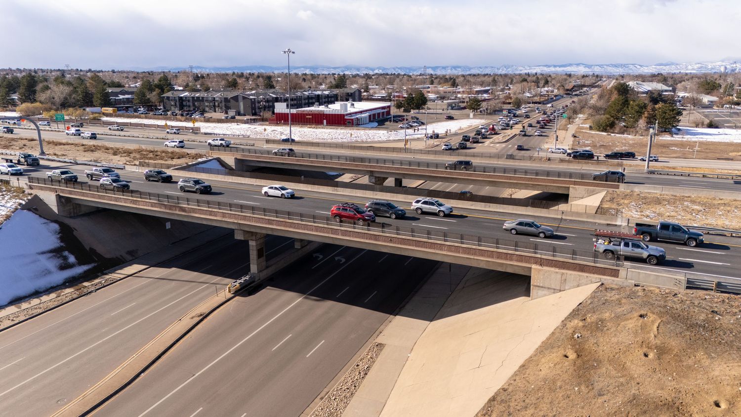A panoramic aerial view of a major highway interchange with multiple lanes and overpasses in an arid landscape.