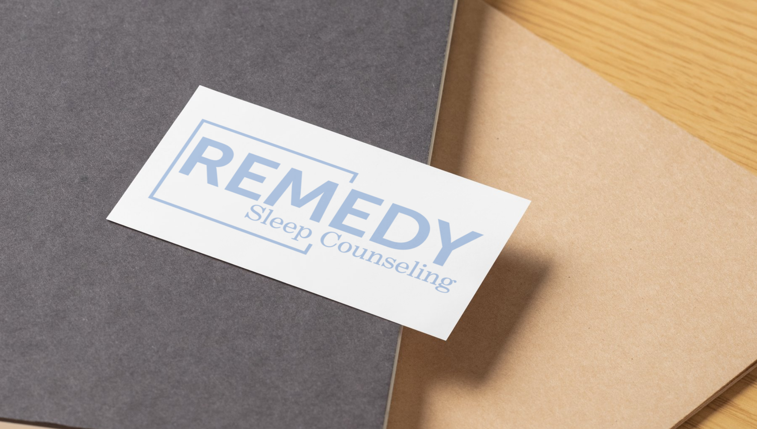 A close-up view of white business cards with blue text displaying 'REMEDY' scattered on a gray surface.
